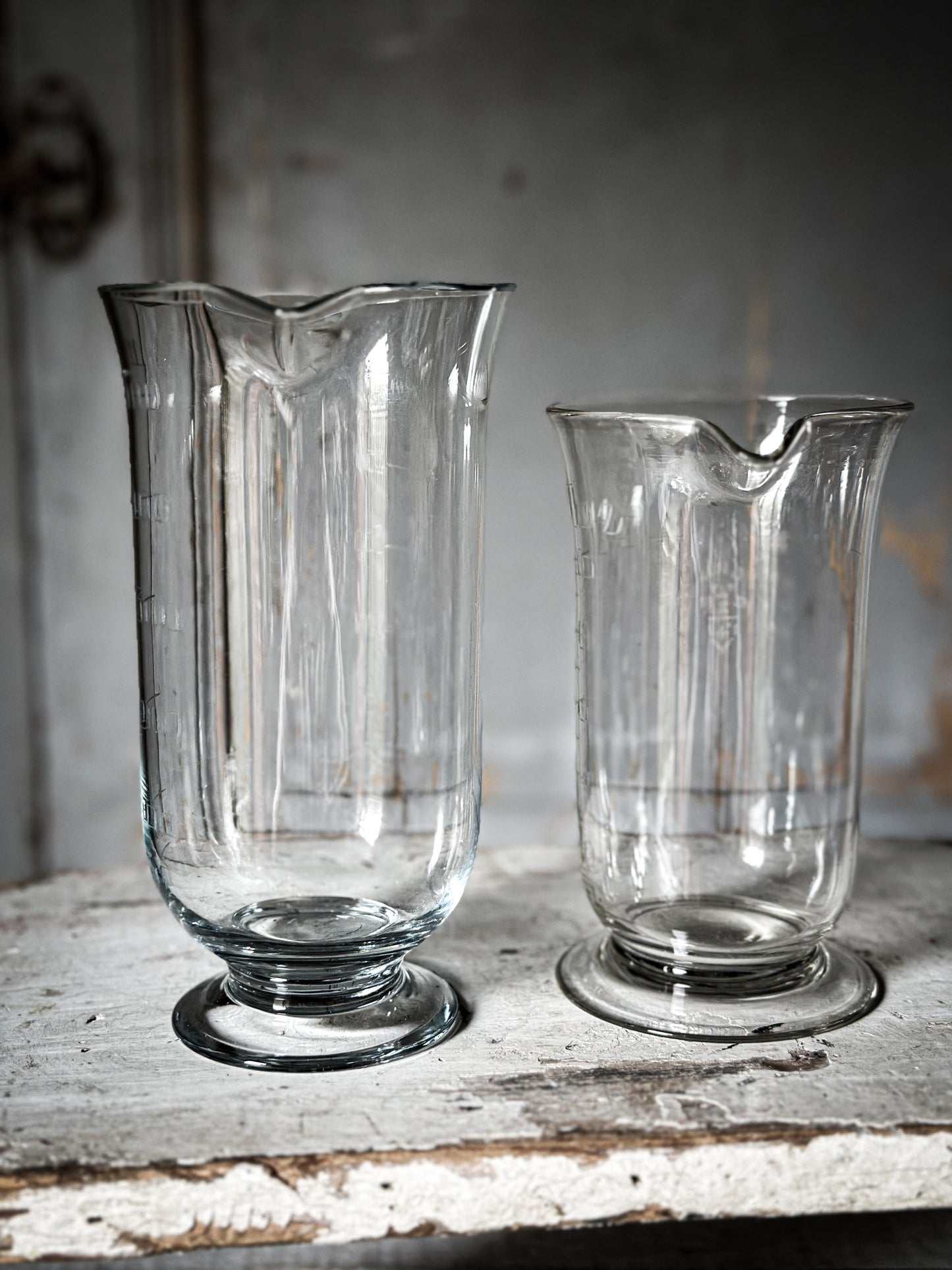 A pair of wonderful antique etched glass apothecary measures