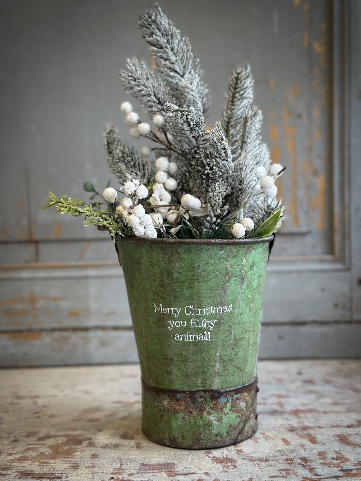 A Recycled Metal Mini Christmas Tree Bucket With A Hand Painted Quote