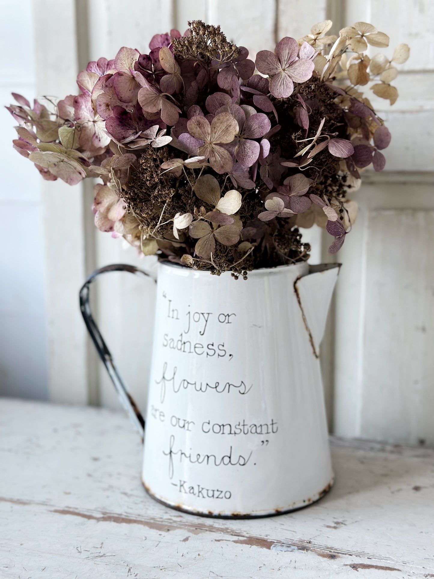 A hand painted quote on a beautiful Vintage white enamelware jug