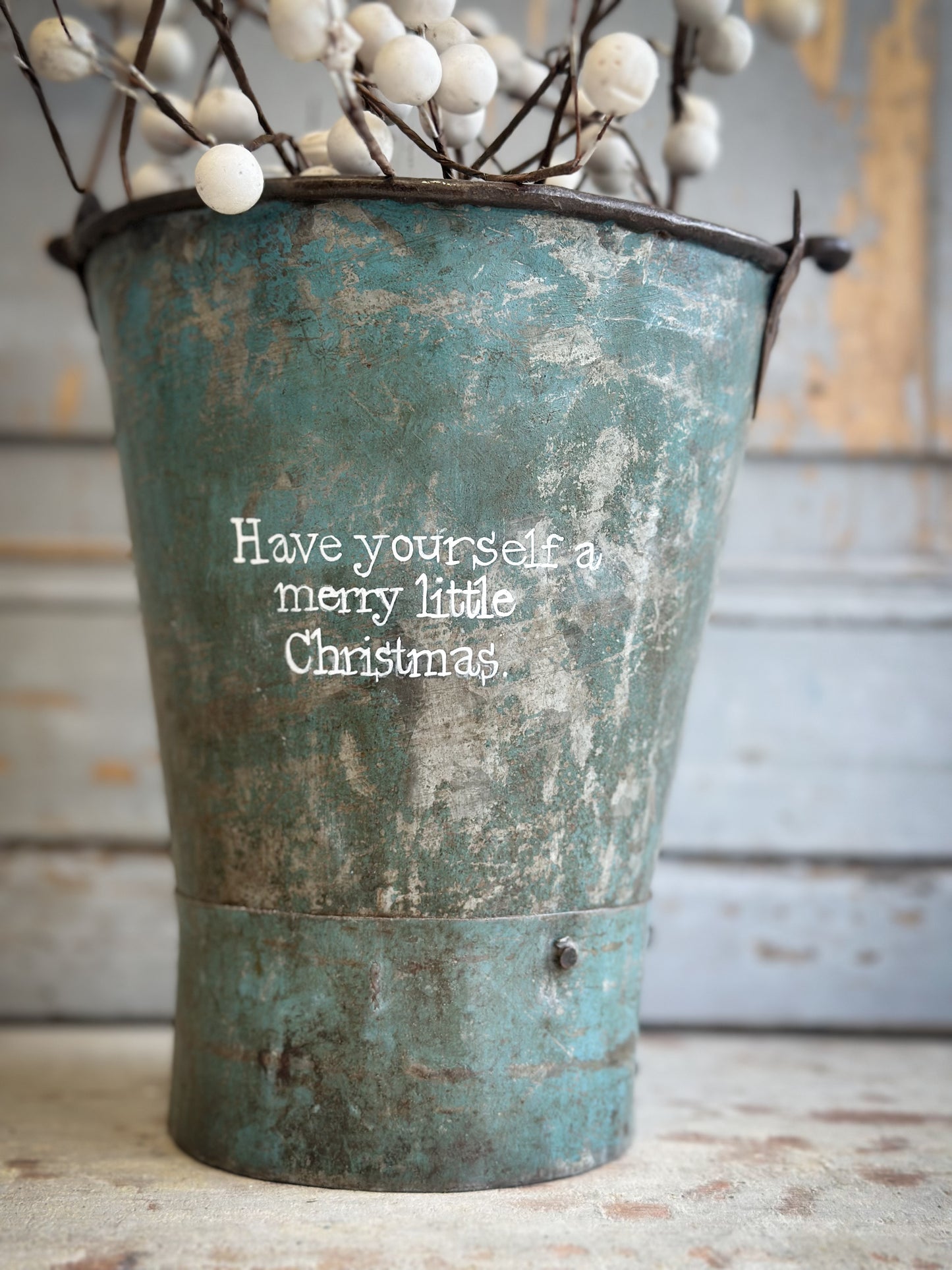 A Recycled Metal Mini Christmas Tree Bucket With A Hand Painted Quote