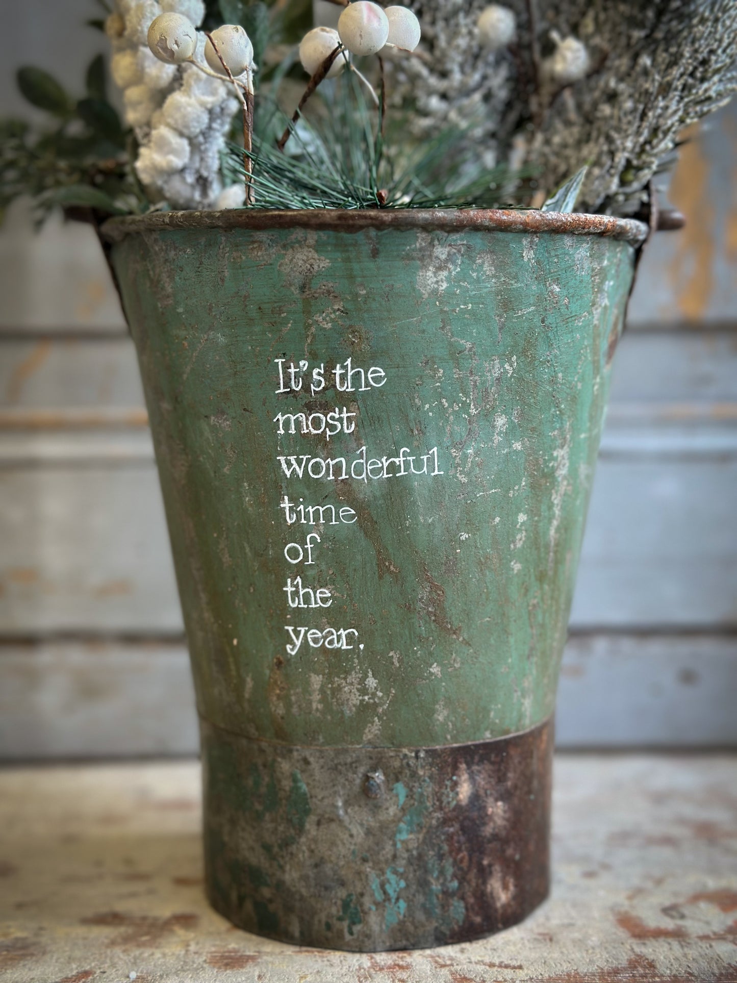 A Recycled Metal Mini Christmas Tree Bucket With A Hand Painted Quote