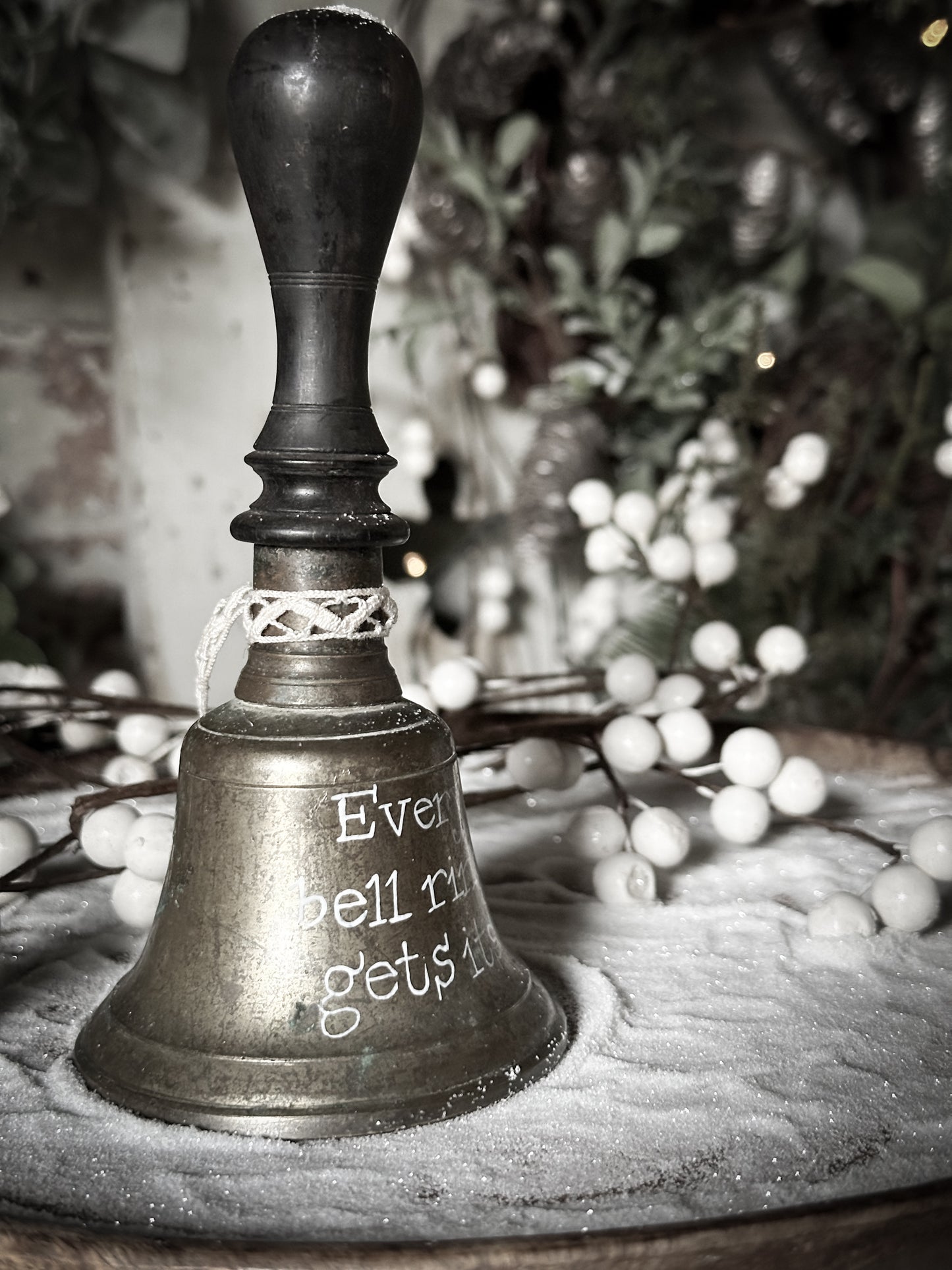 A vintage brass hand held bell with a hand painted quote