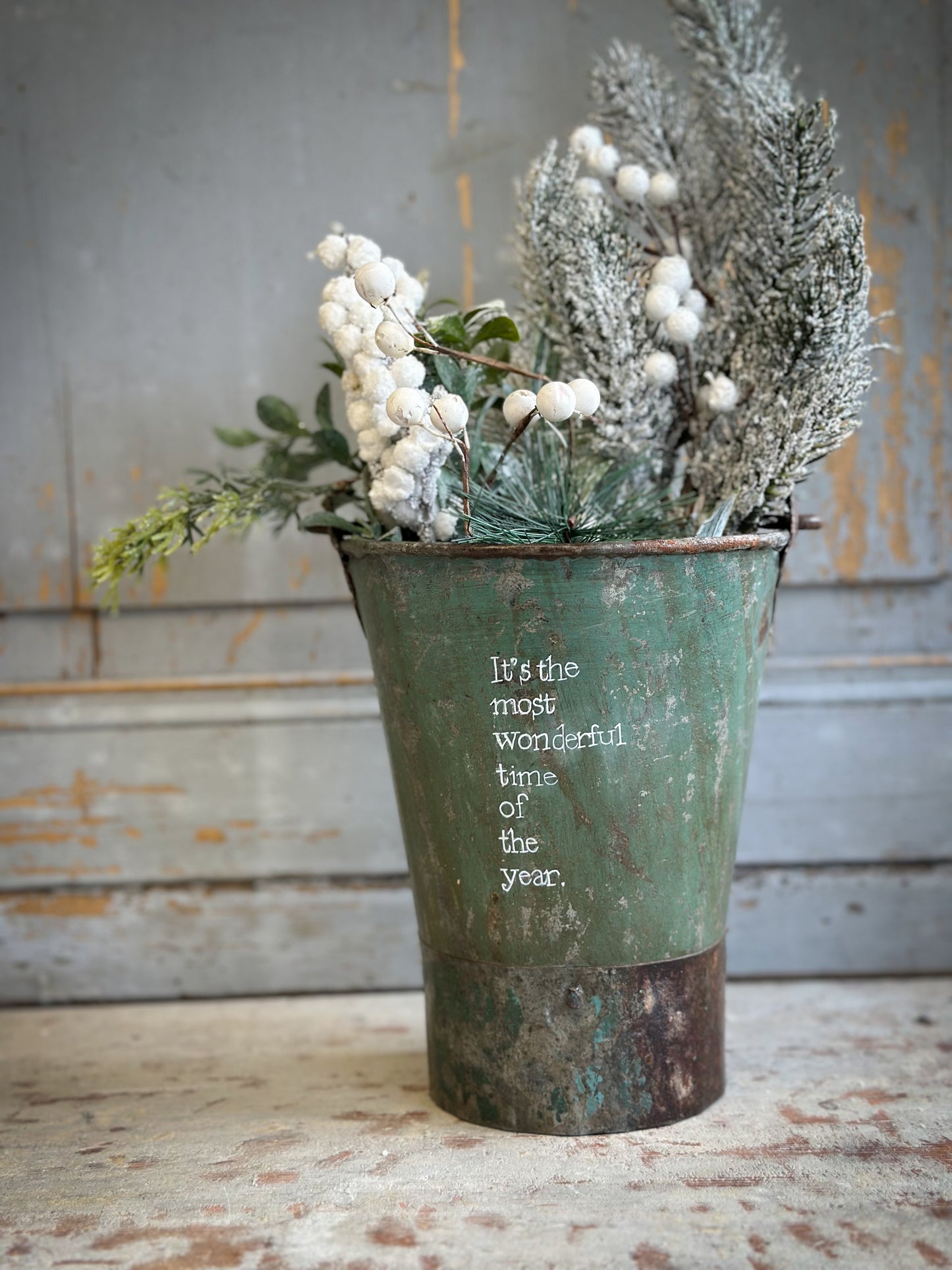 A Recycled Metal Mini Christmas Tree Bucket With A Hand Painted Quote
