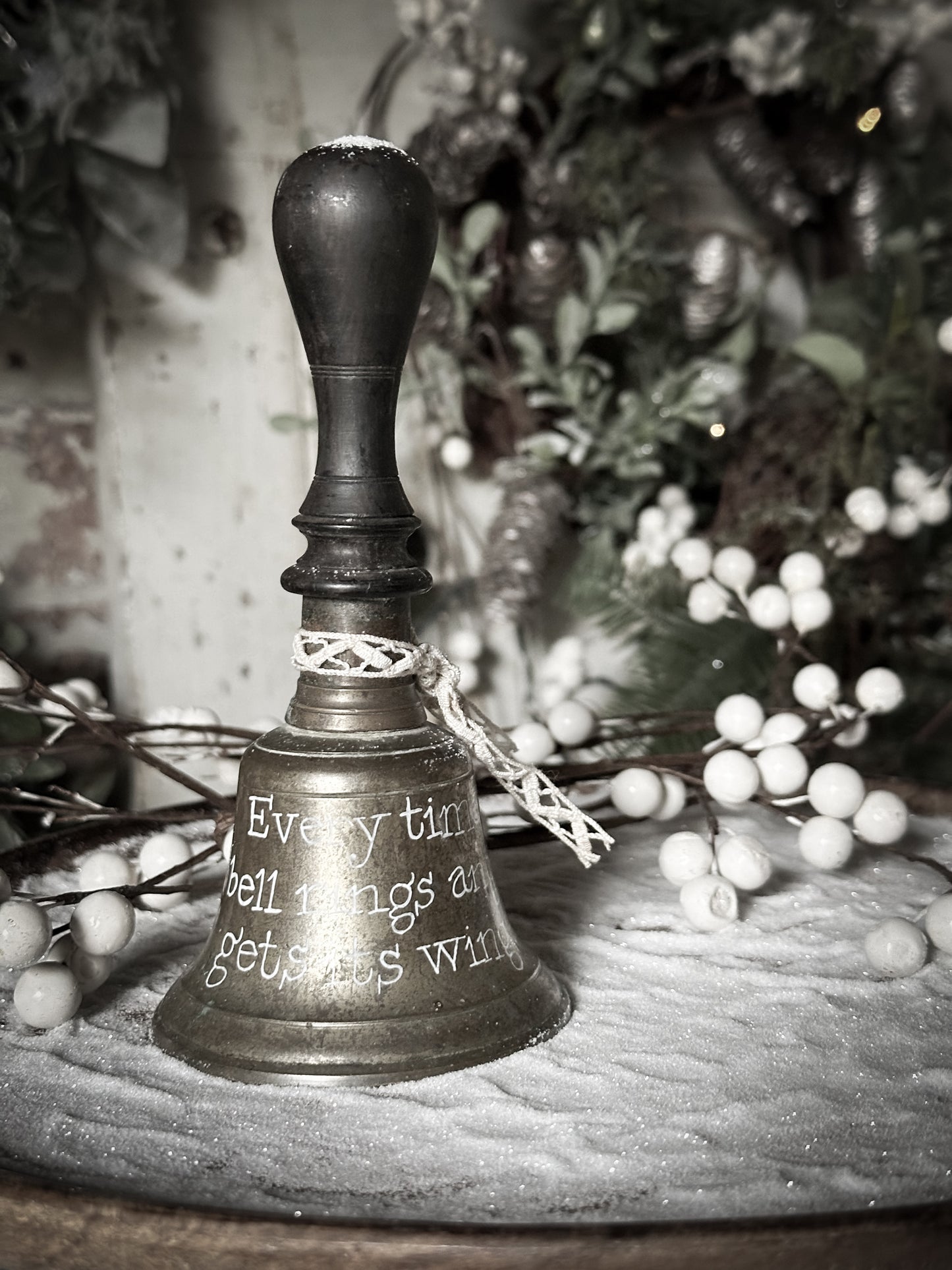 A vintage brass hand held bell with a hand painted quote