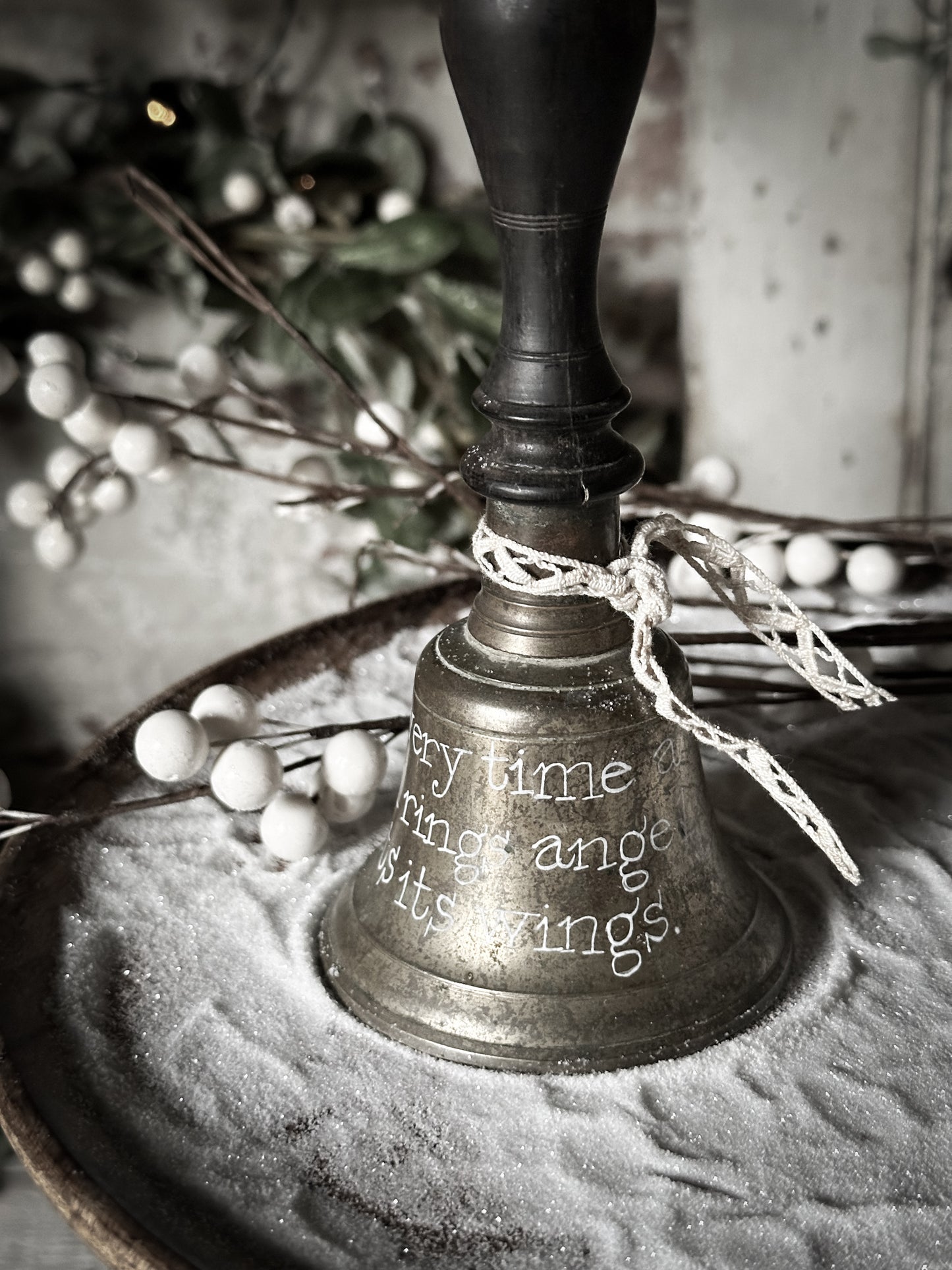 A vintage brass hand held bell with a hand painted quote