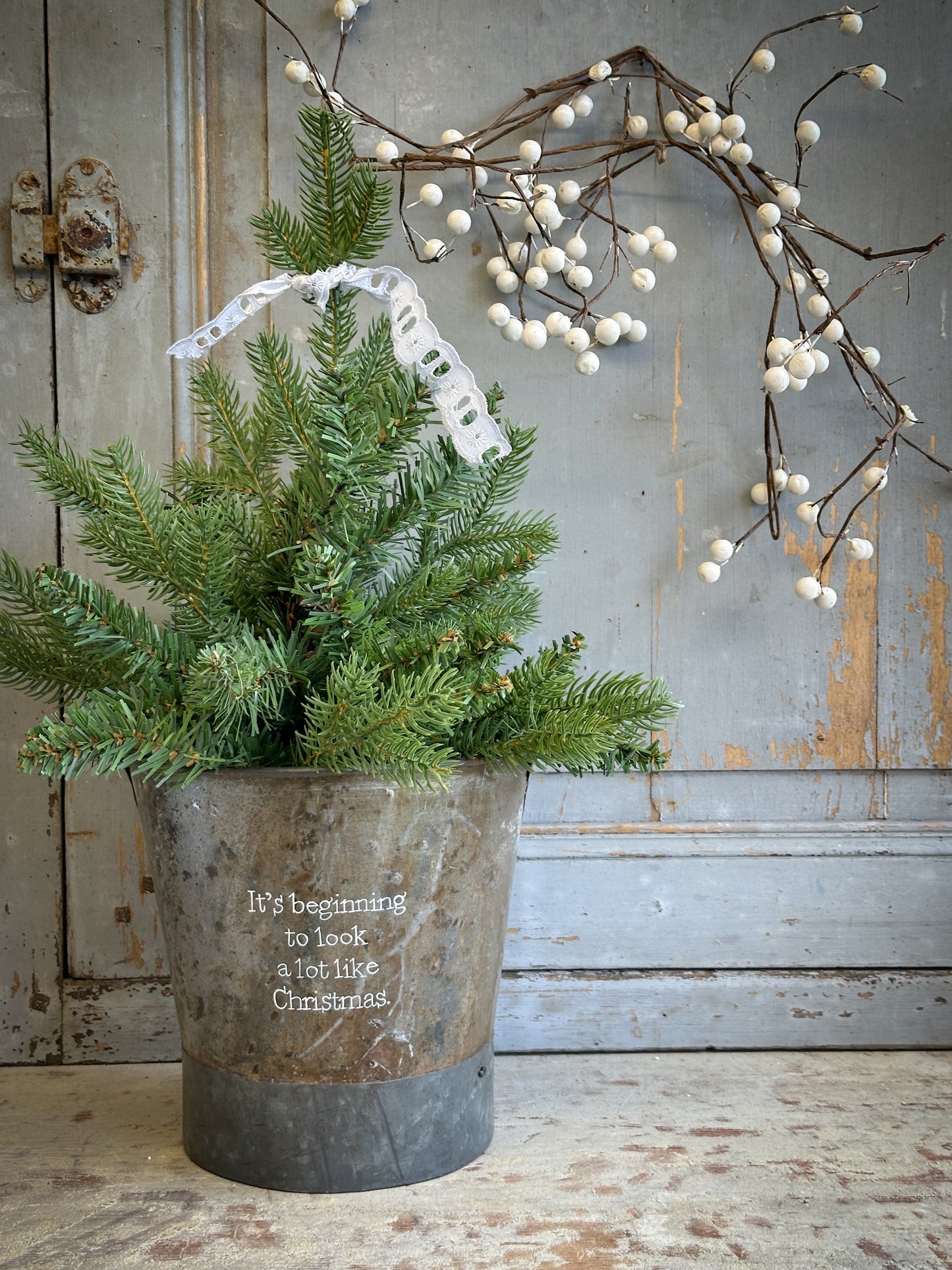 A Recycled Metal Small Christmas Tree Bucket With A Hand Painted Quote