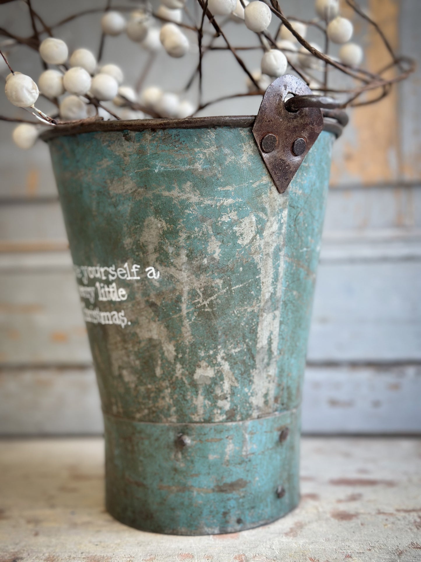 A Recycled Metal Mini Christmas Tree Bucket With A Hand Painted Quote