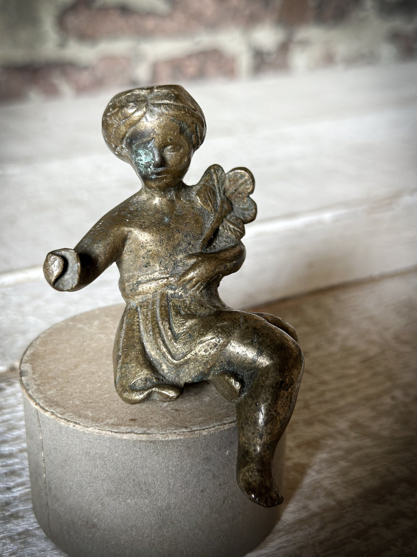 A Delightful Antique Bronze Decorative Seated Cherub