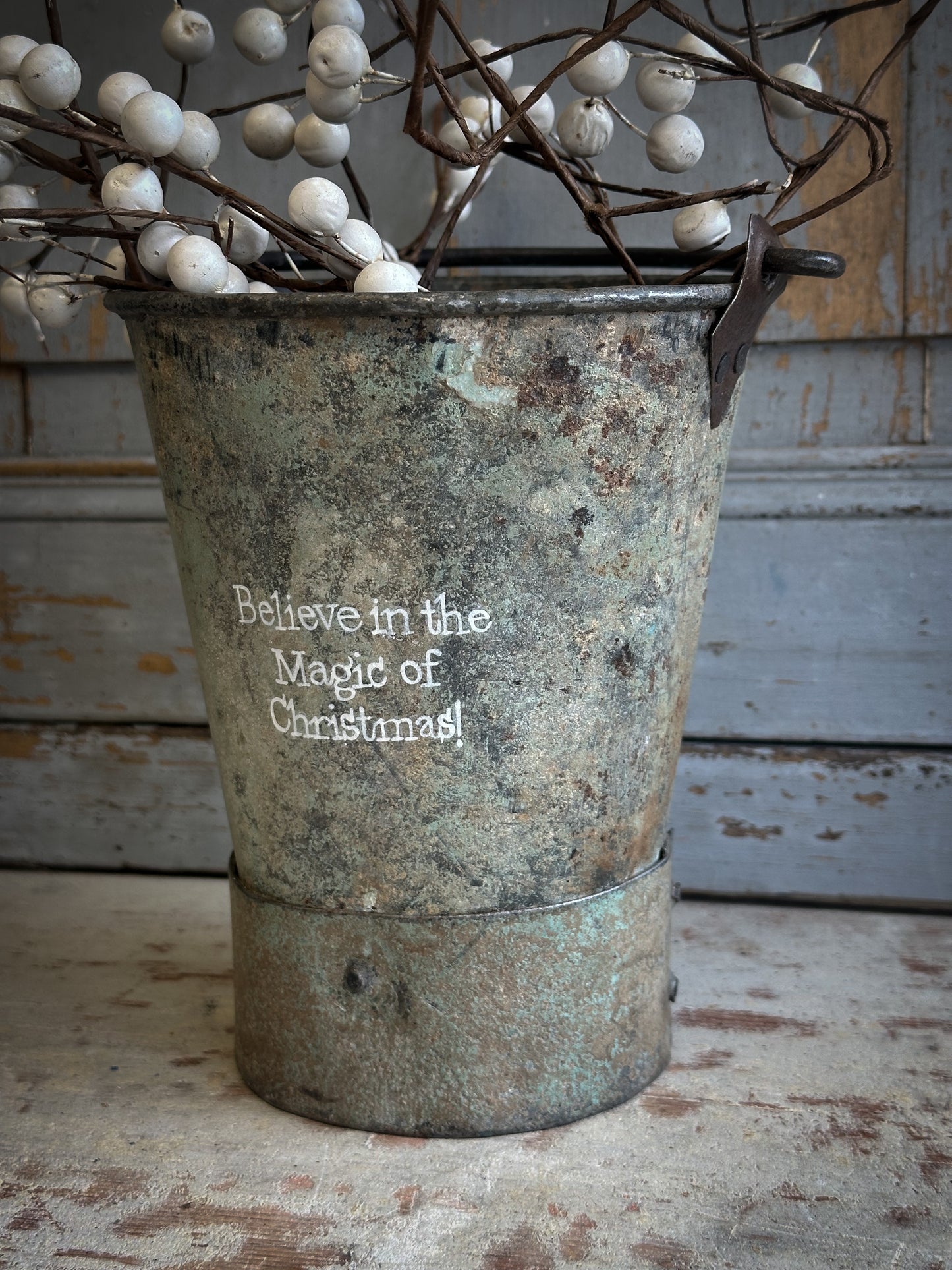 A Recycled Metal Mini Christmas Tree Bucket With A Hand Painted Quote