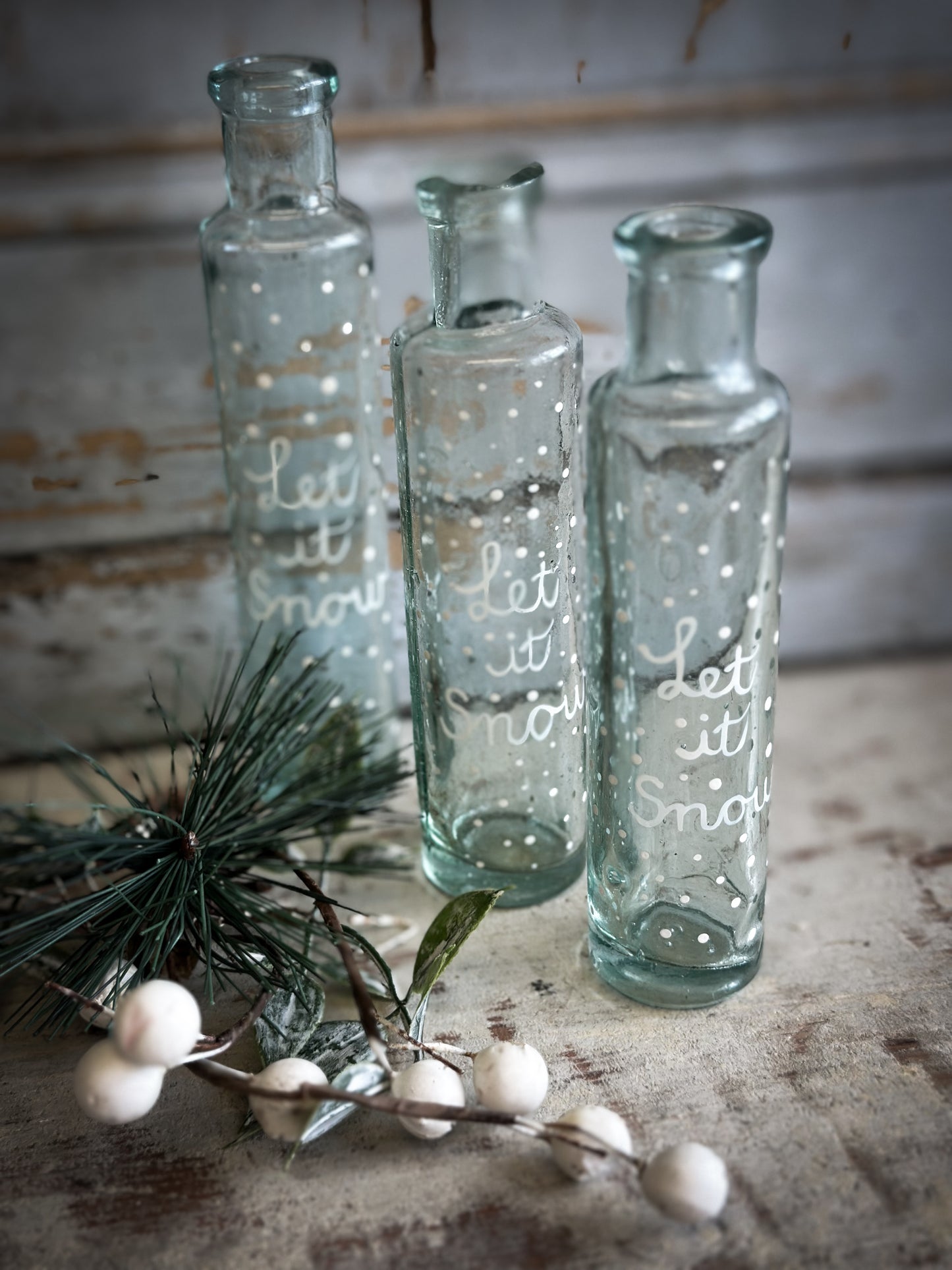 A beautiful Victorian cylinder bottle painted with a Christmas quote “Let it Snow”