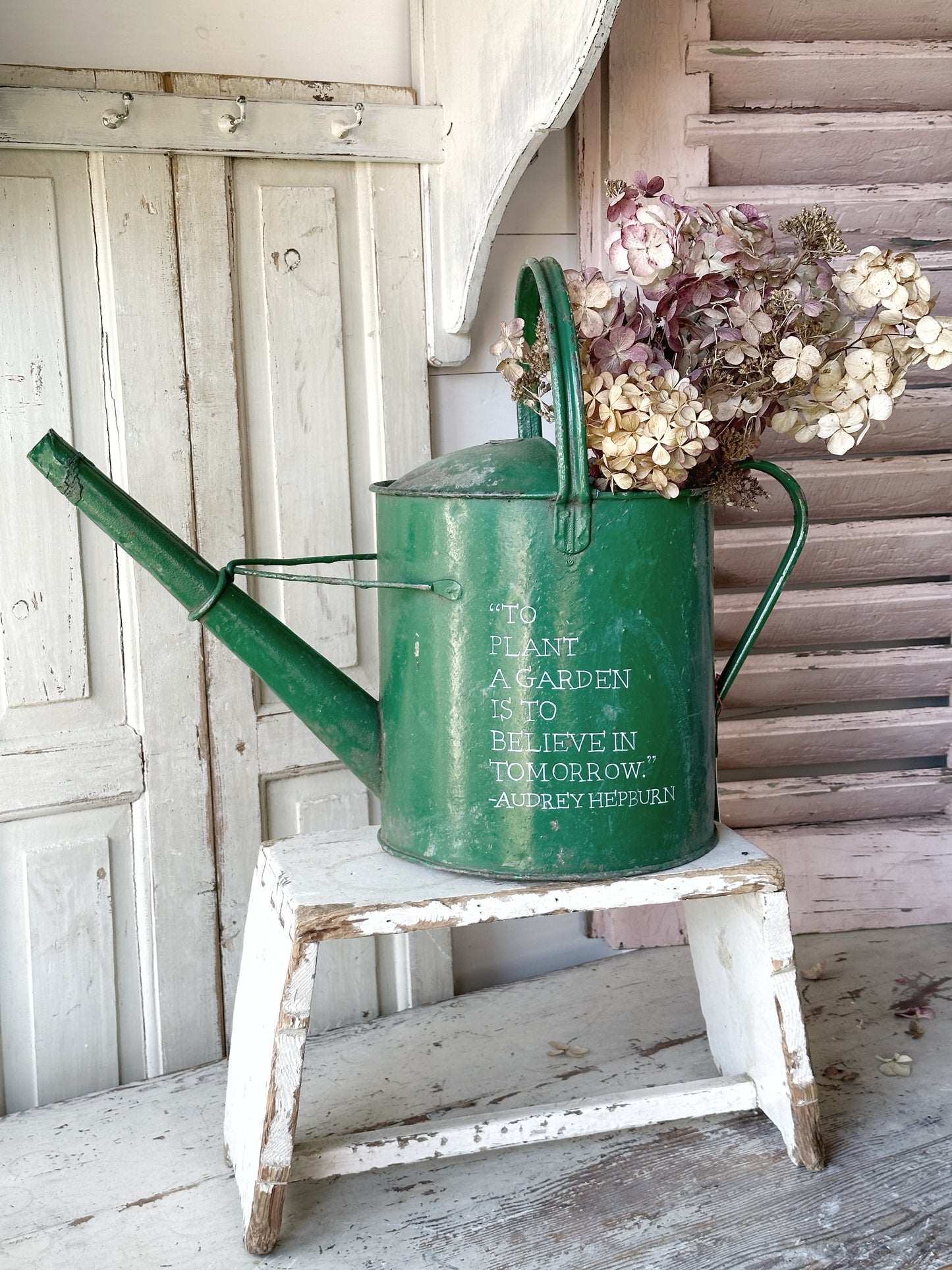 A lovely vintage galvanised watering can painted in a green coloured paint