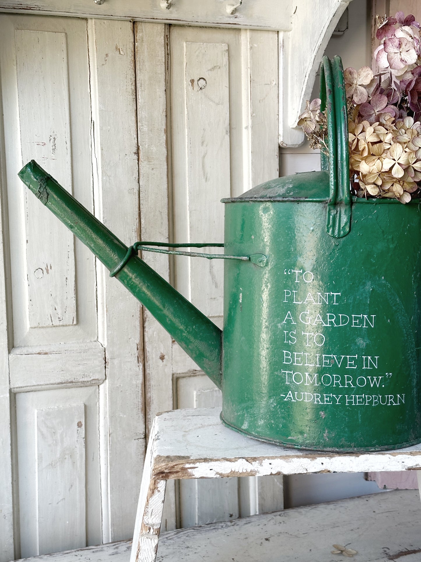 A lovely vintage galvanised watering can painted in a green coloured paint