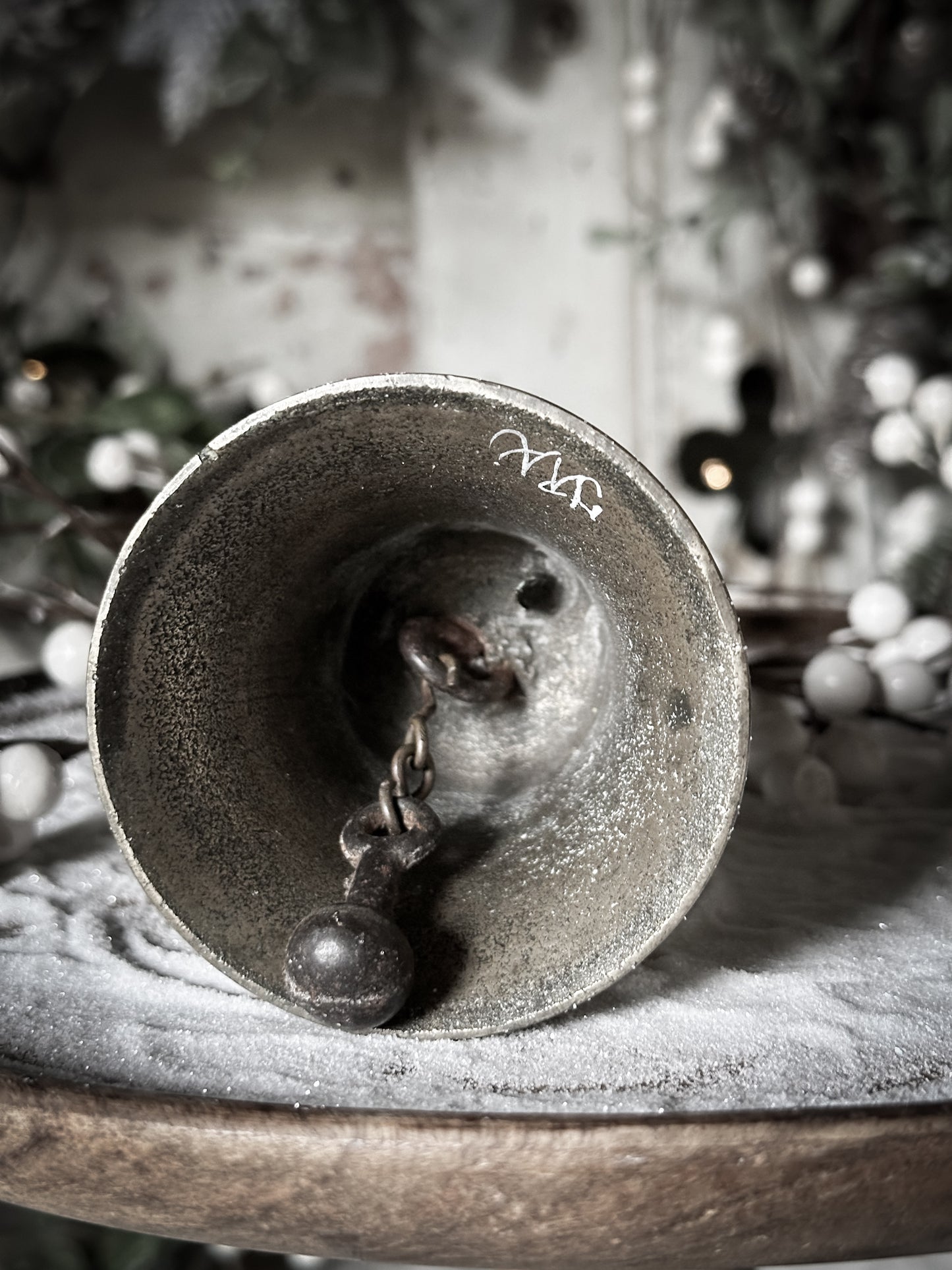 A vintage brass hand held bell with a hand painted quote