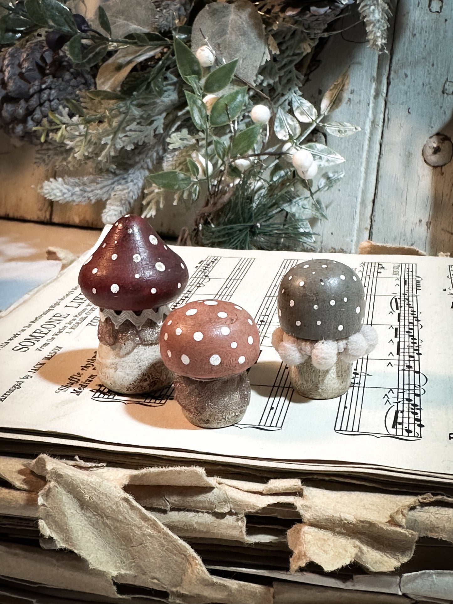 A set of three wooden hand painted and trimmed Christmas village toadstools
