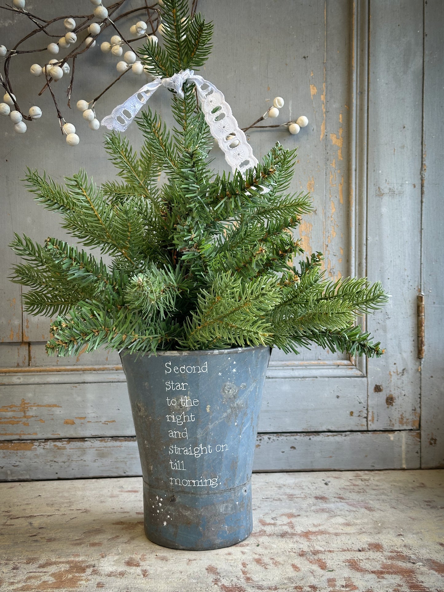 A Recycled Metal Mini Christmas Tree Bucket With A Hand Painted Quote