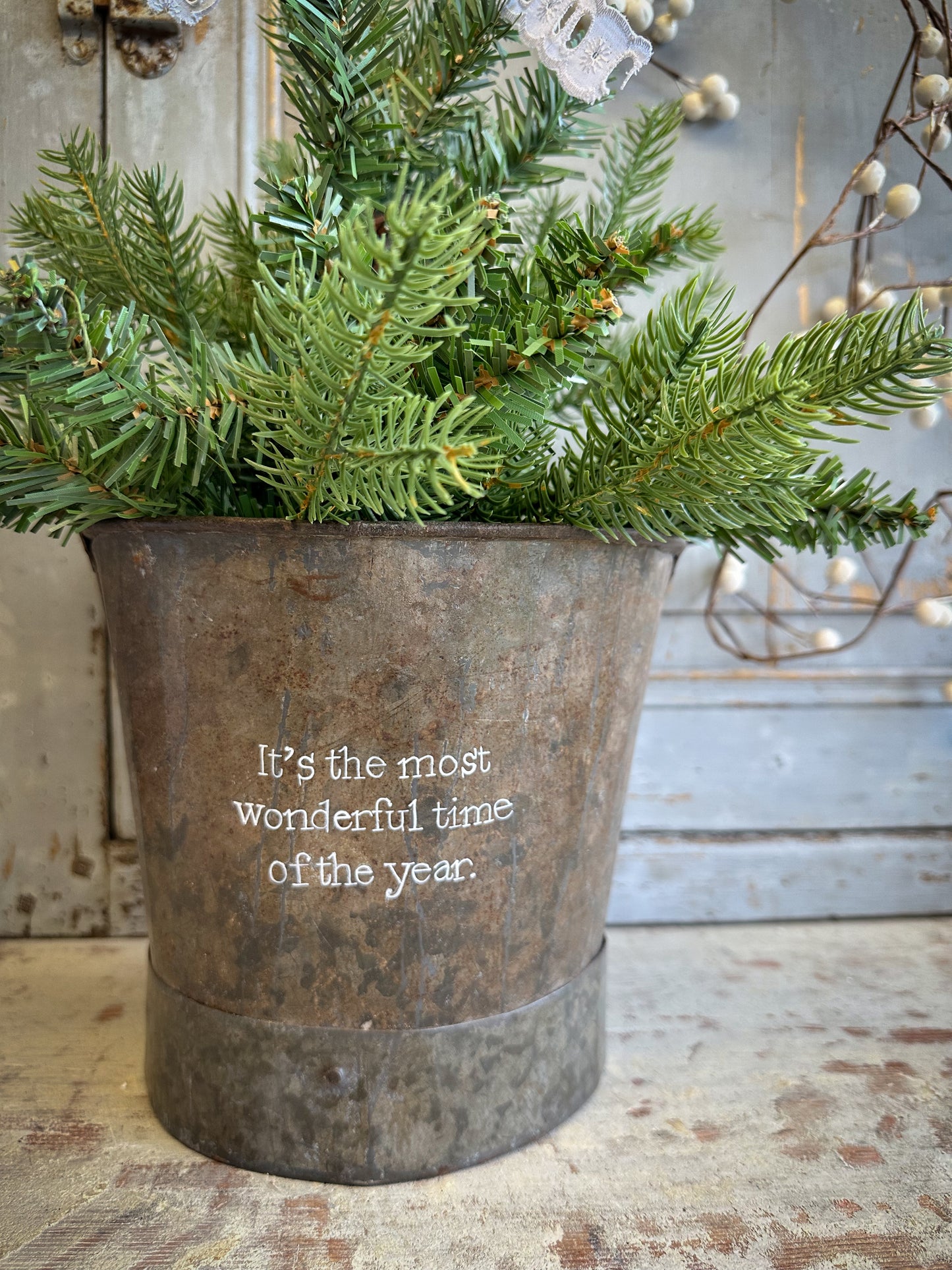 A Recycled Metal Small Christmas Tree Bucket With A Hand Painted Quote