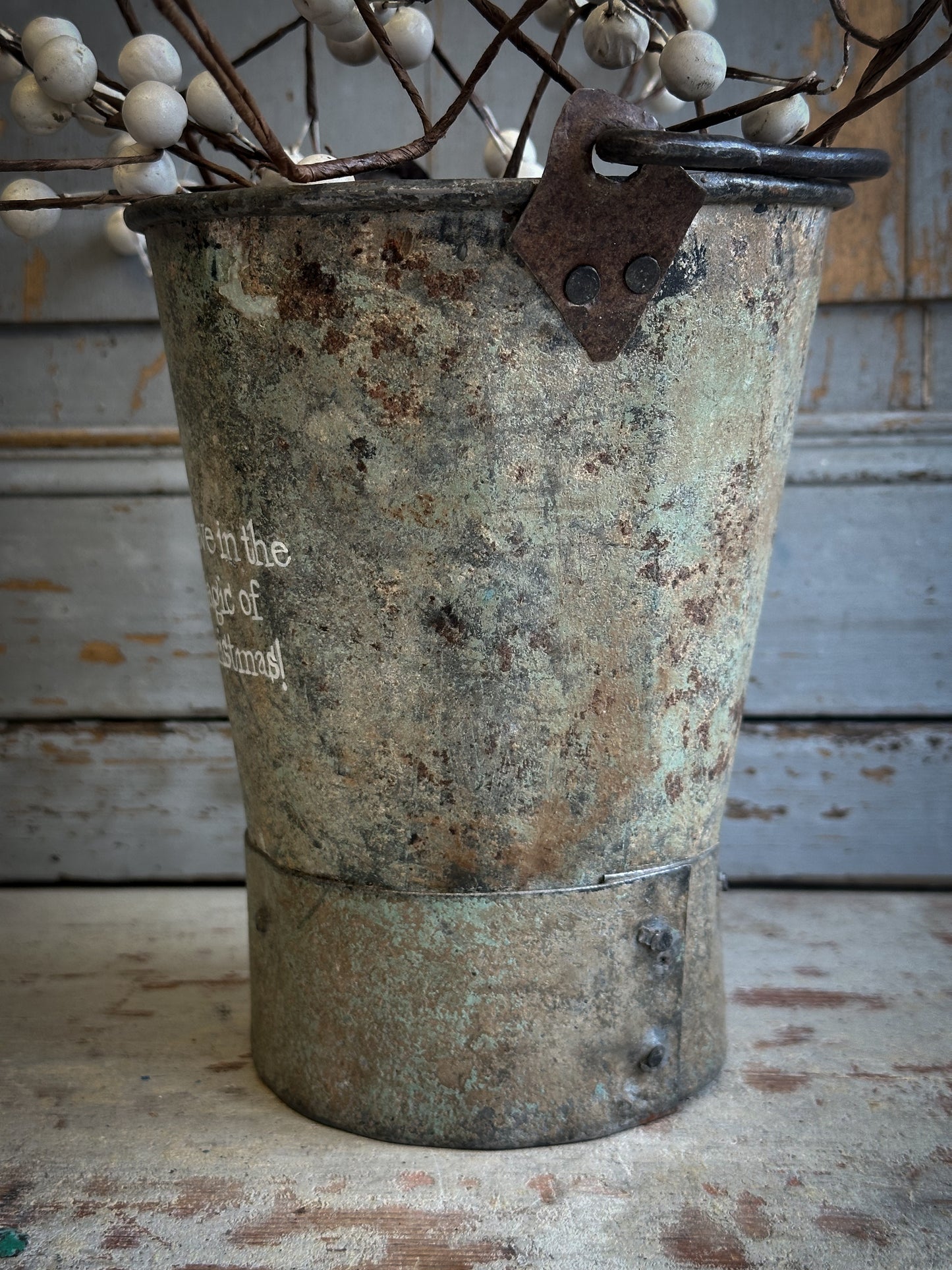 A Recycled Metal Mini Christmas Tree Bucket With A Hand Painted Quote