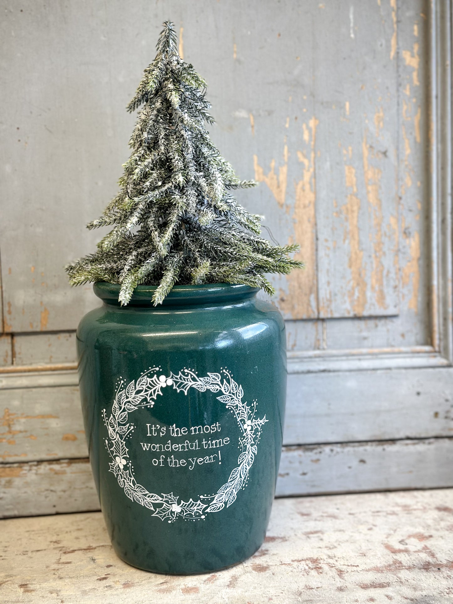 A large Emerald Green Antique Creamery Vase Bottle with a Hand Painted Wreath and Christmas Quote