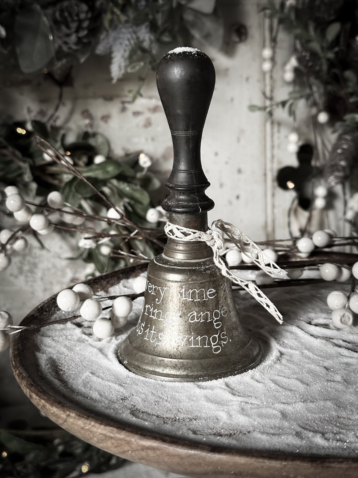 A vintage brass hand held bell with a hand painted quote