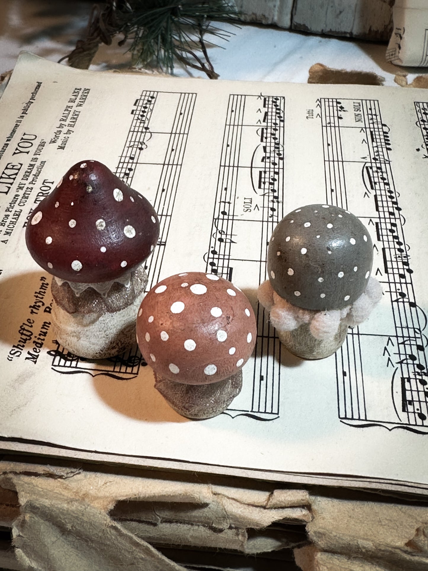 A set of three wooden hand painted and trimmed Christmas village toadstools