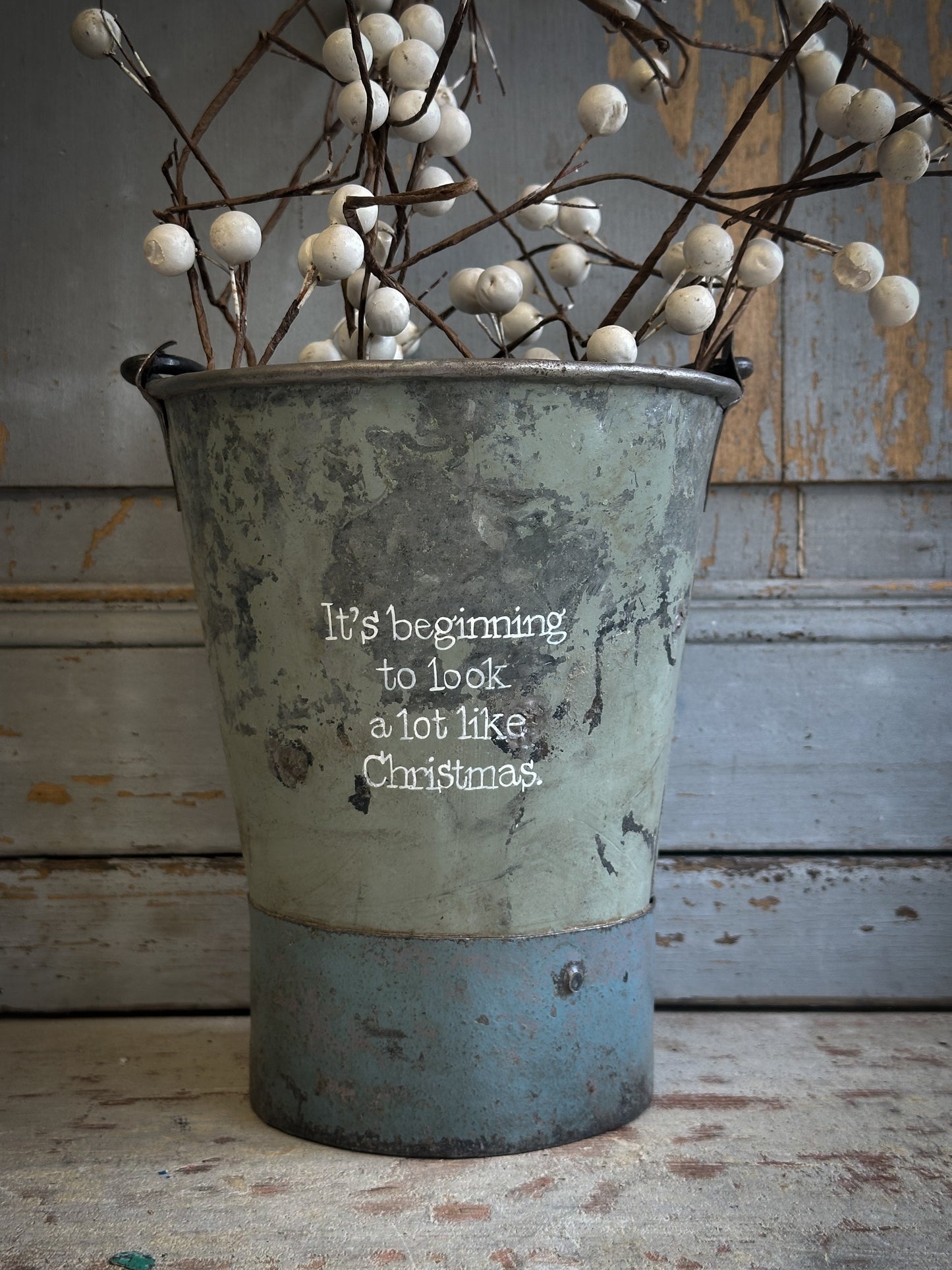 A Recycled Metal Mini Christmas Tree Bucket With A Hand Painted Quote