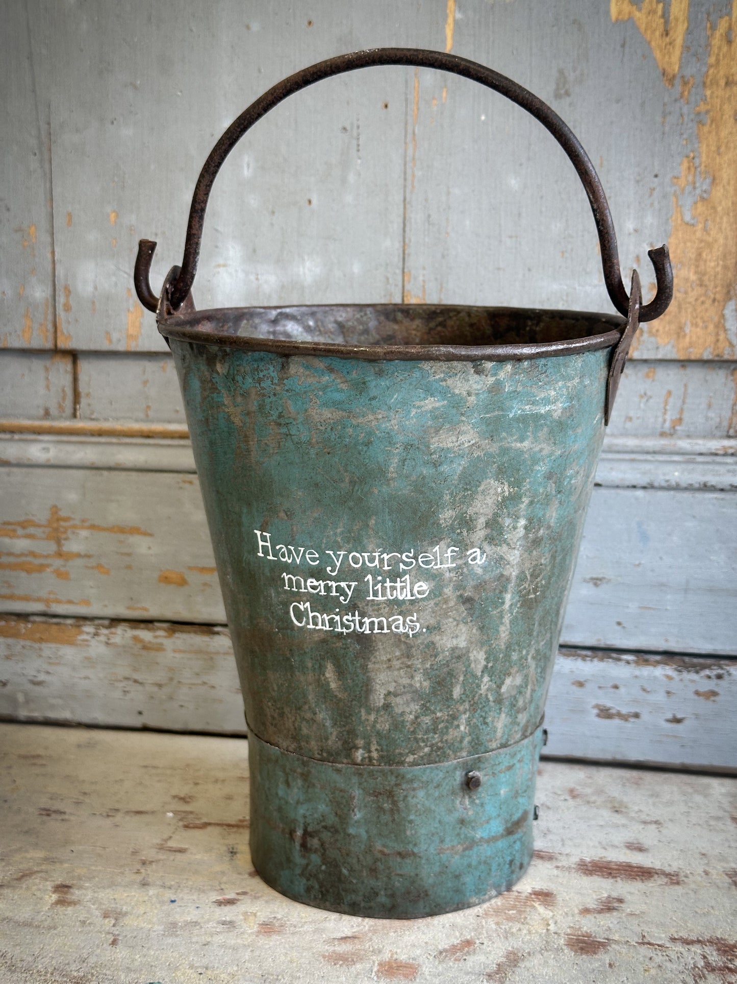A Recycled Metal Mini Christmas Tree Bucket With A Hand Painted Quote