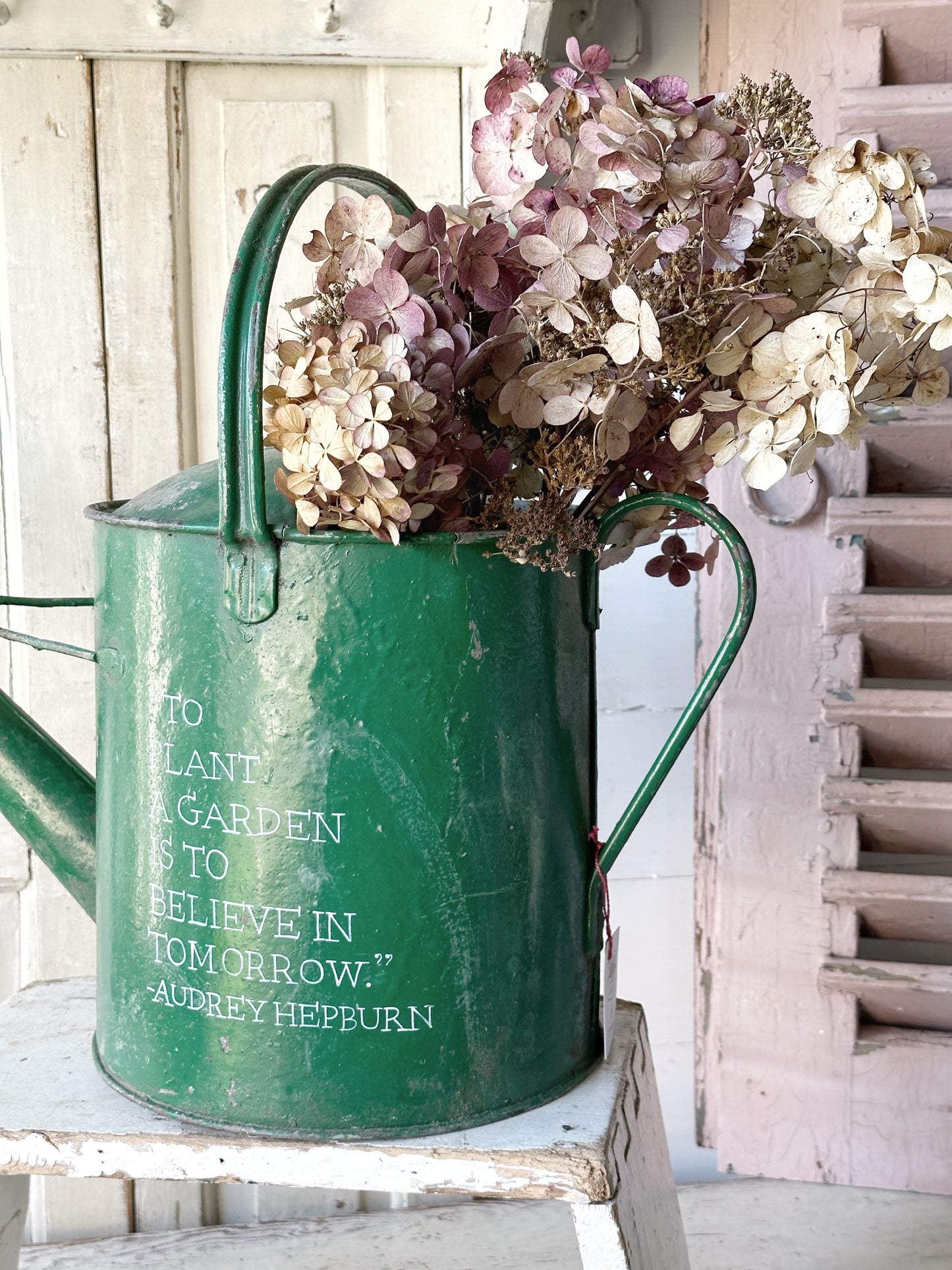 A lovely vintage galvanised watering can painted in a green coloured paint