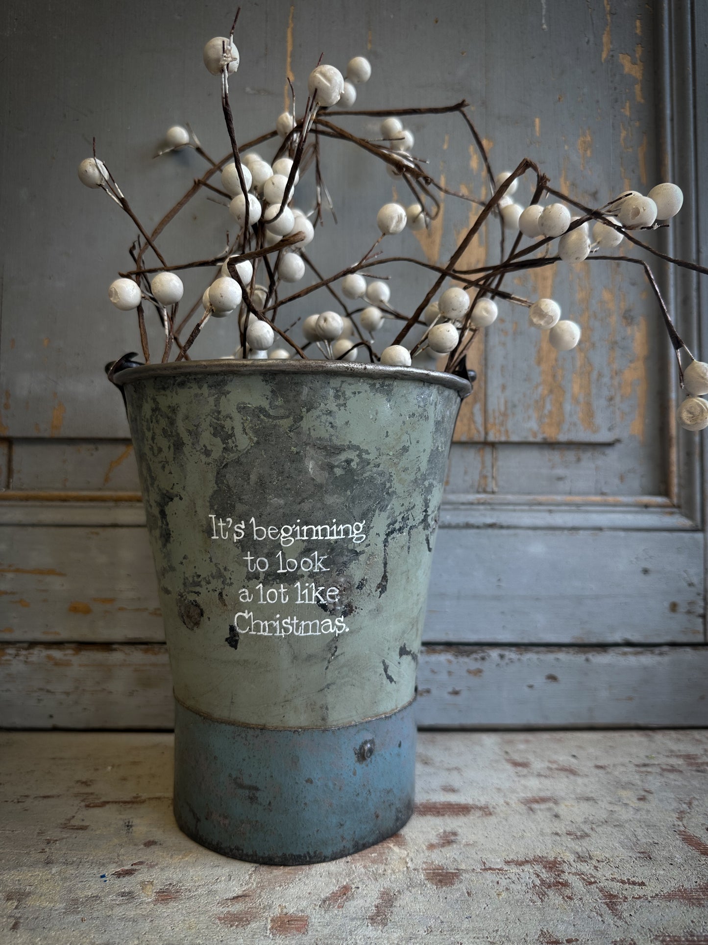 A Recycled Metal Mini Christmas Tree Bucket With A Hand Painted Quote