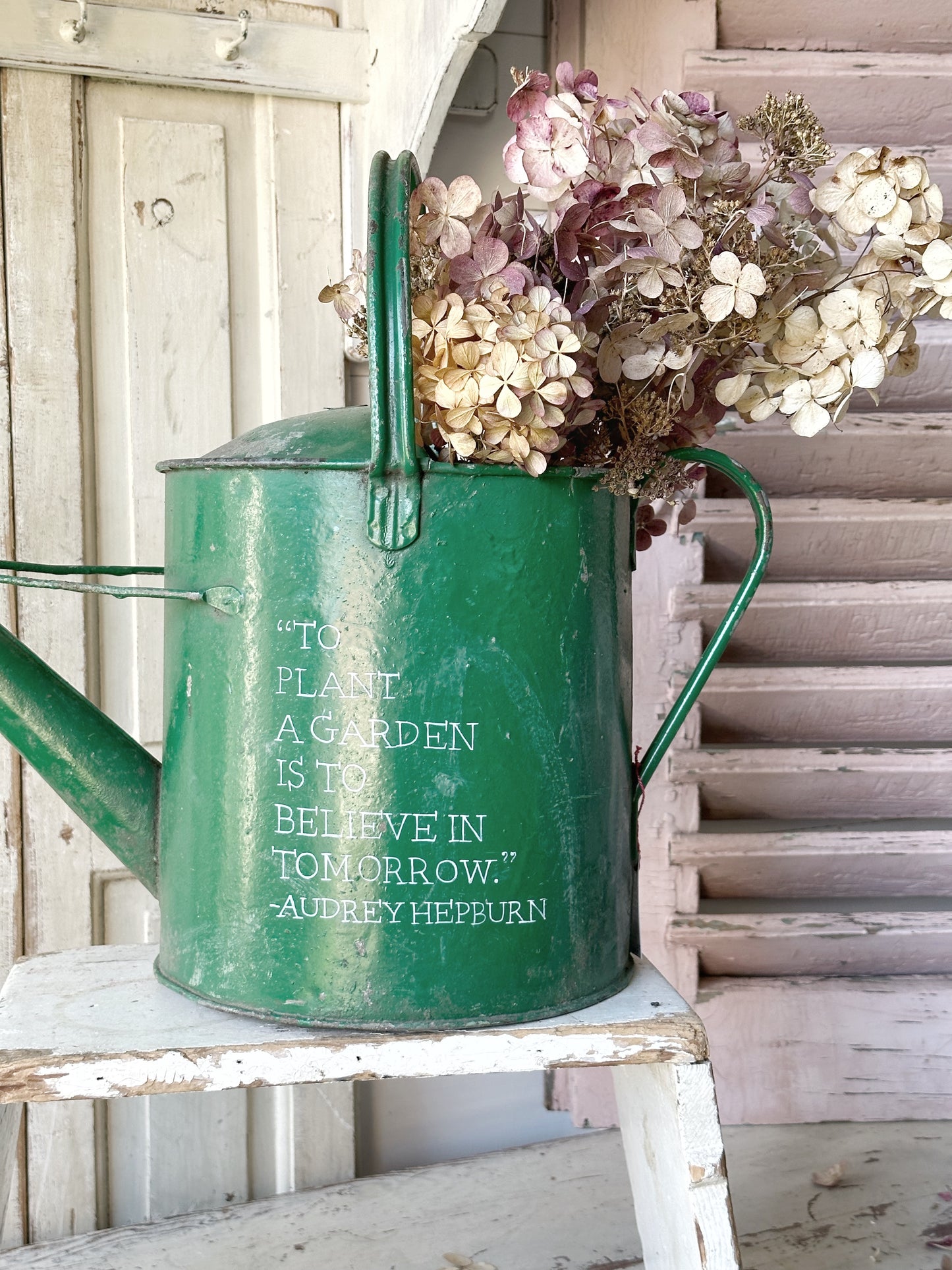 A lovely vintage galvanised watering can painted in a green coloured paint