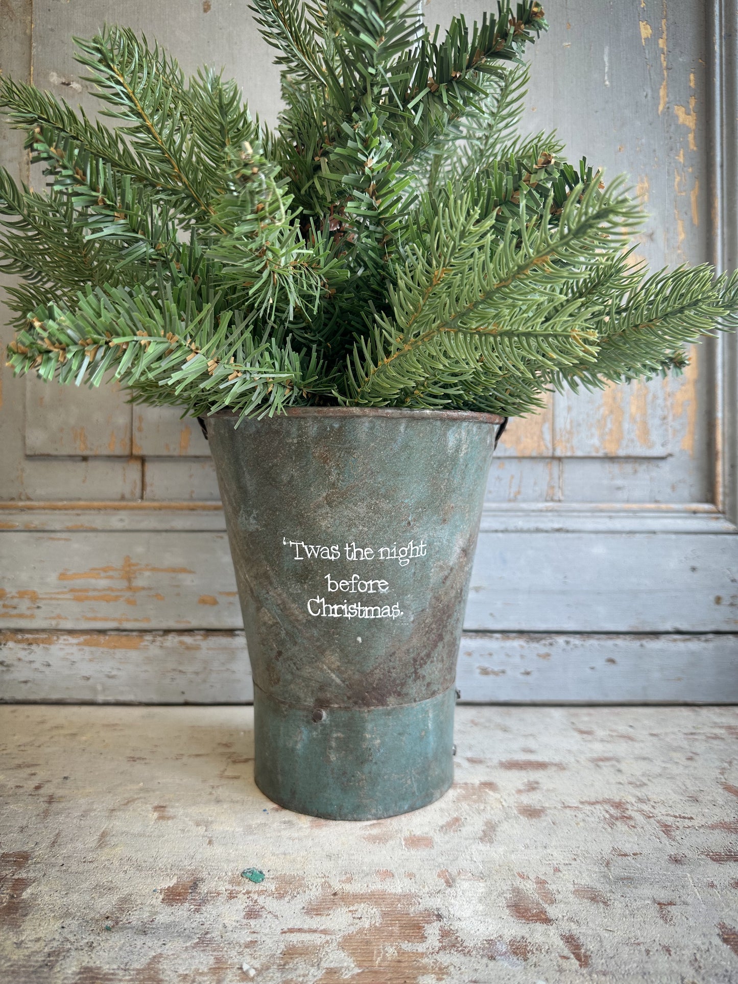 A Recycled Metal Mini Christmas Tree Bucket With A Hand Painted Quote