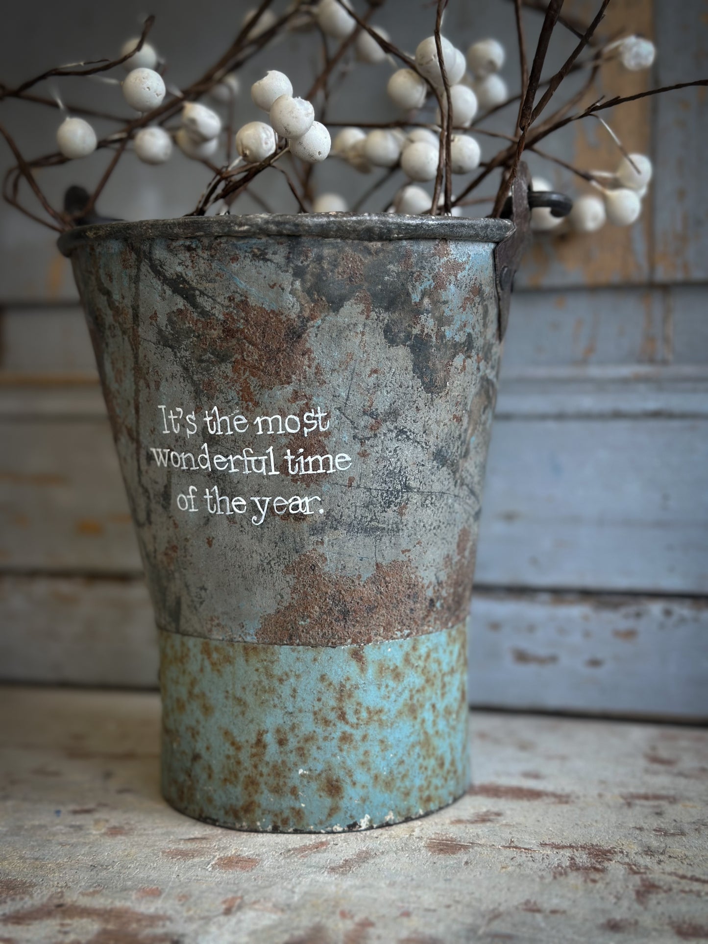 A Recycled Metal Mini Christmas Tree Bucket With A Hand Painted Quote