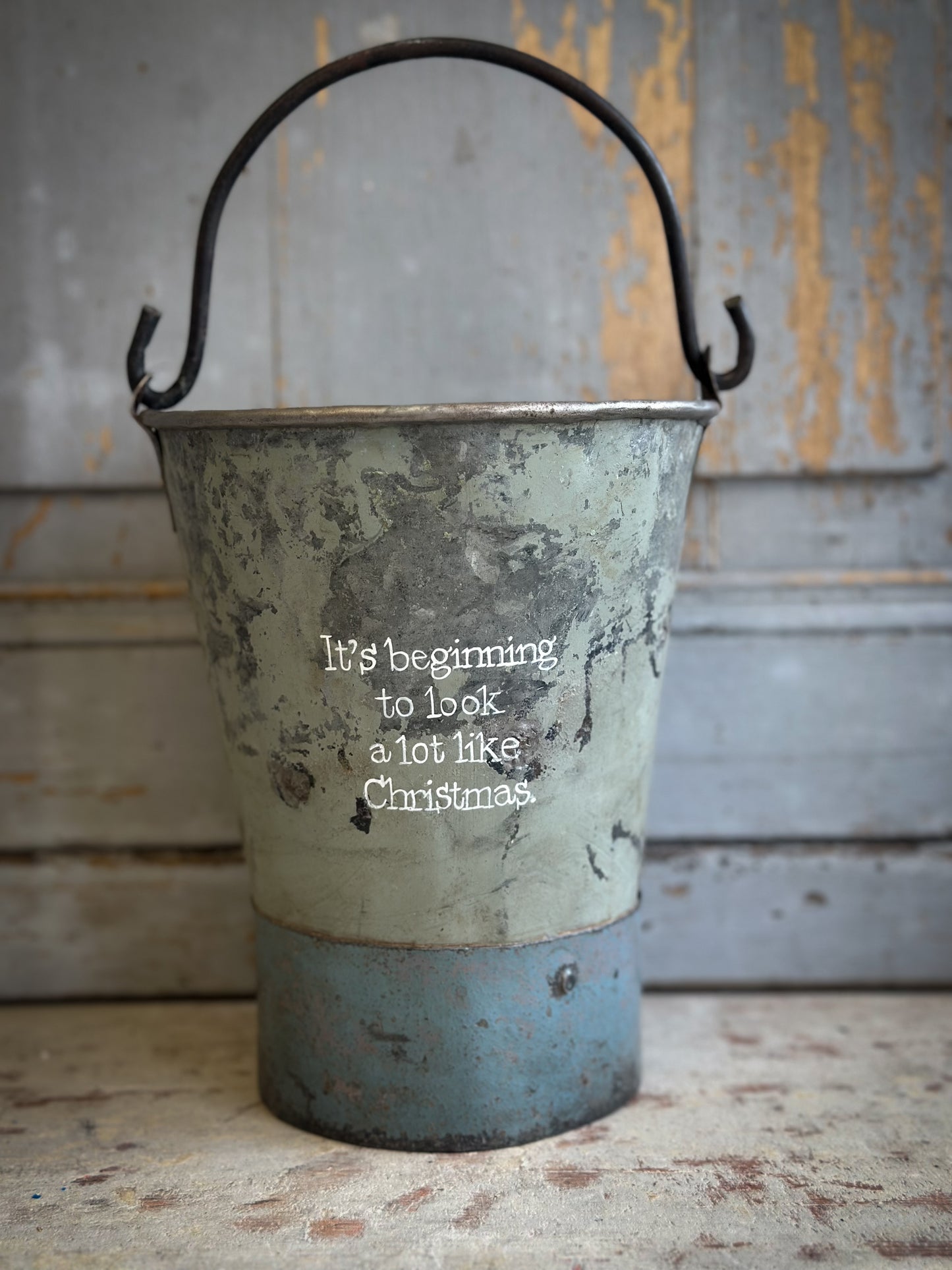 A Recycled Metal Mini Christmas Tree Bucket With A Hand Painted Quote