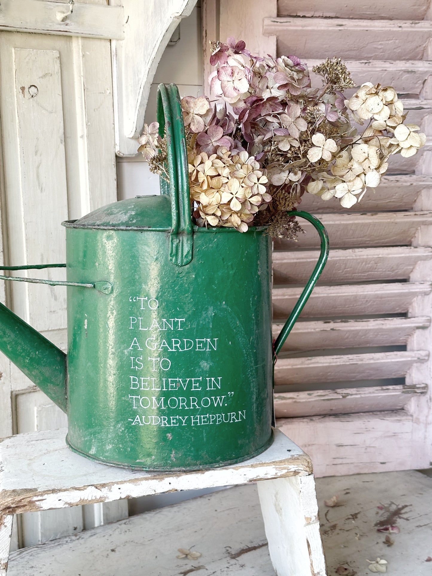 A lovely vintage galvanised watering can painted in a green coloured paint