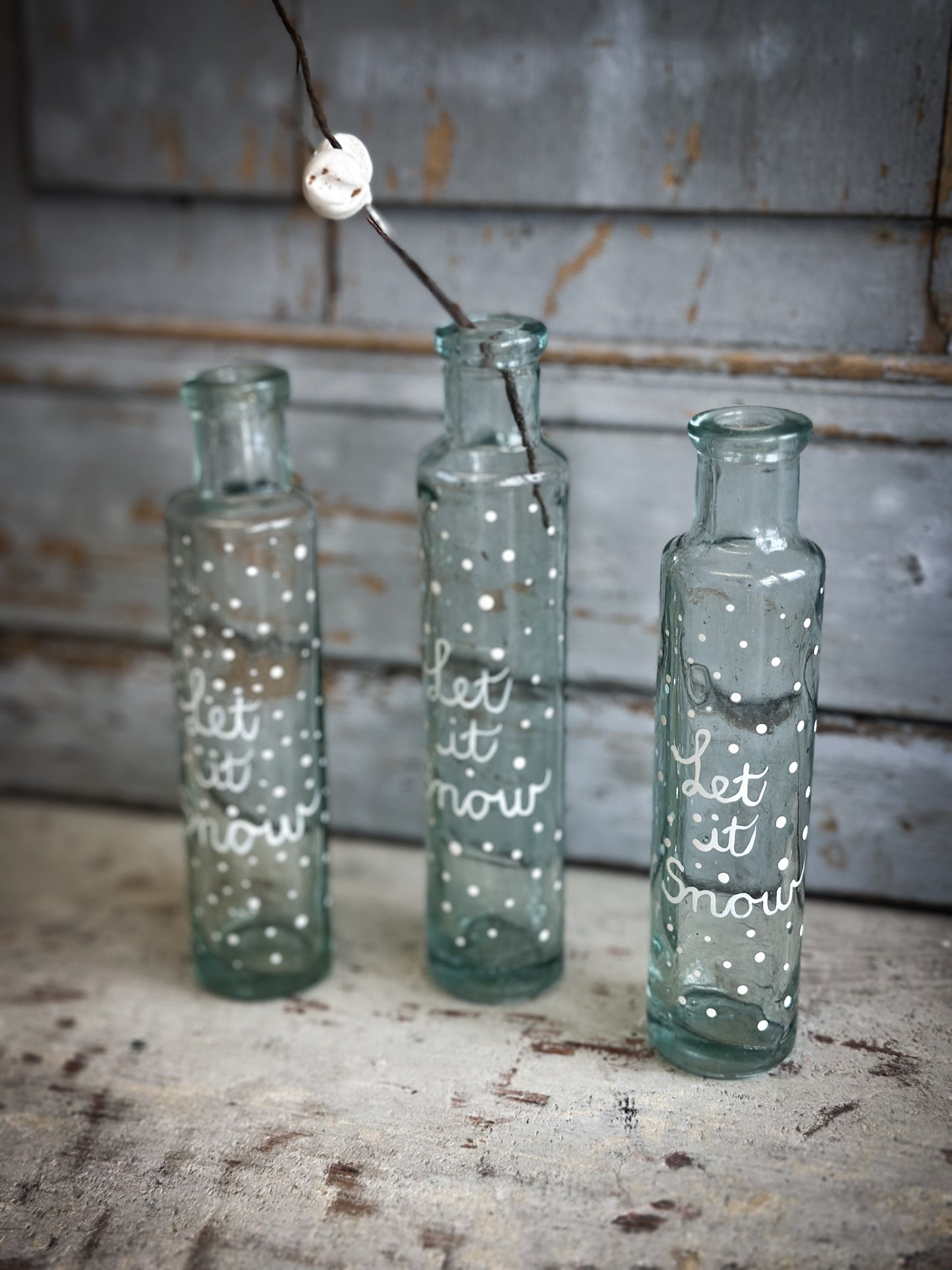 A beautiful Victorian cylinder bottle painted with a Christmas quote “Let it Snow”