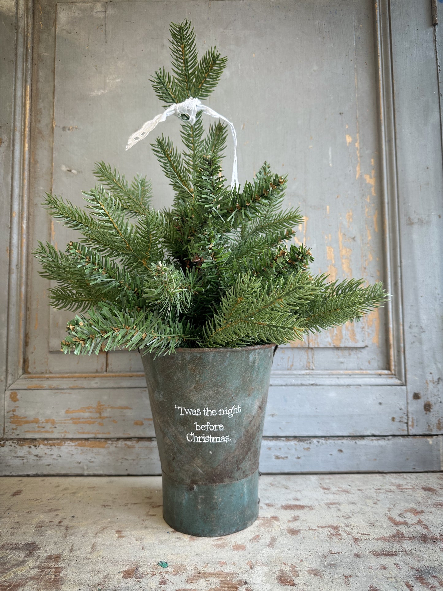 A Recycled Metal Mini Christmas Tree Bucket With A Hand Painted Quote