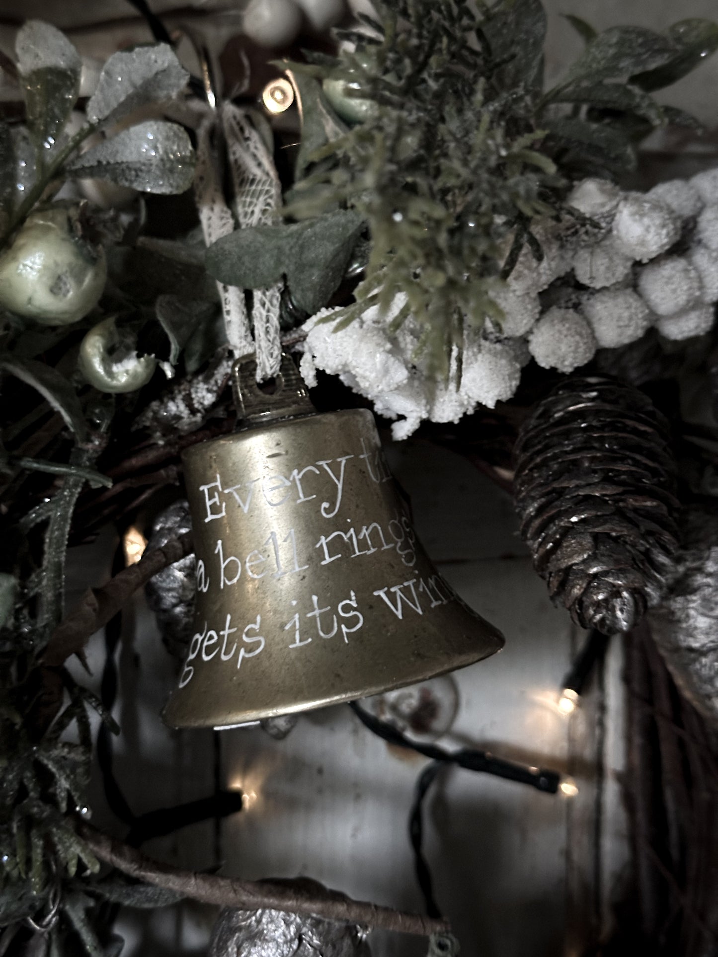 A vintage brass bell with a hand painted quote