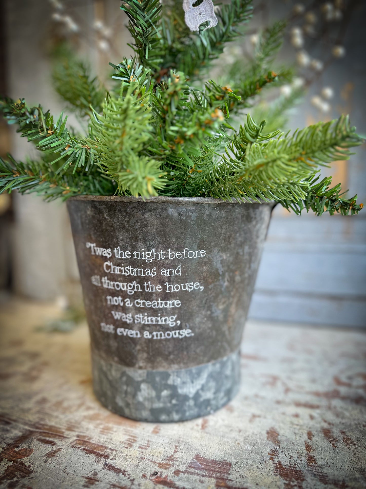 A Recycled Metal Small Christmas Tree Bucket With A Hand Painted Quote
