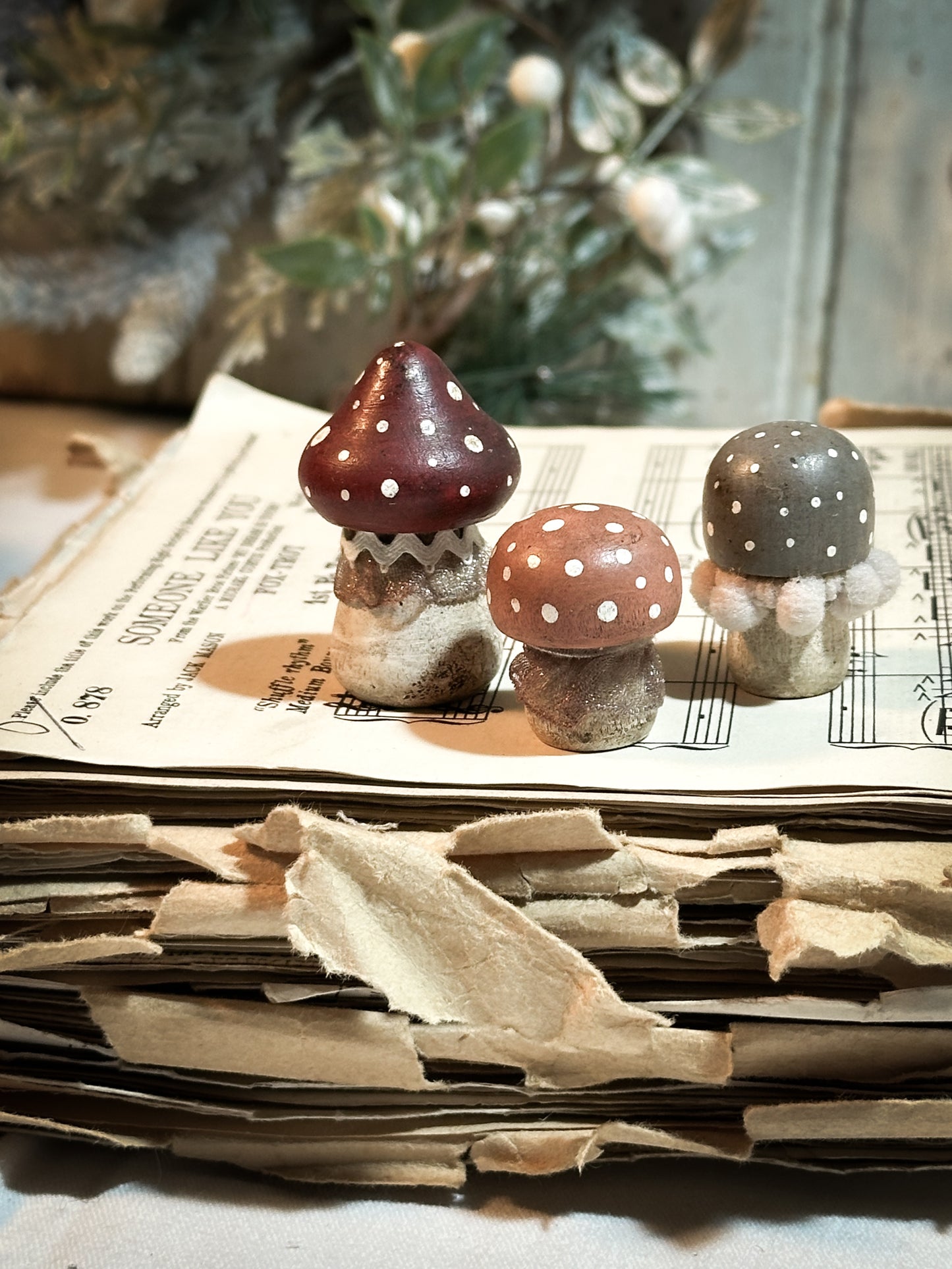 A set of three wooden hand painted and trimmed Christmas village toadstools