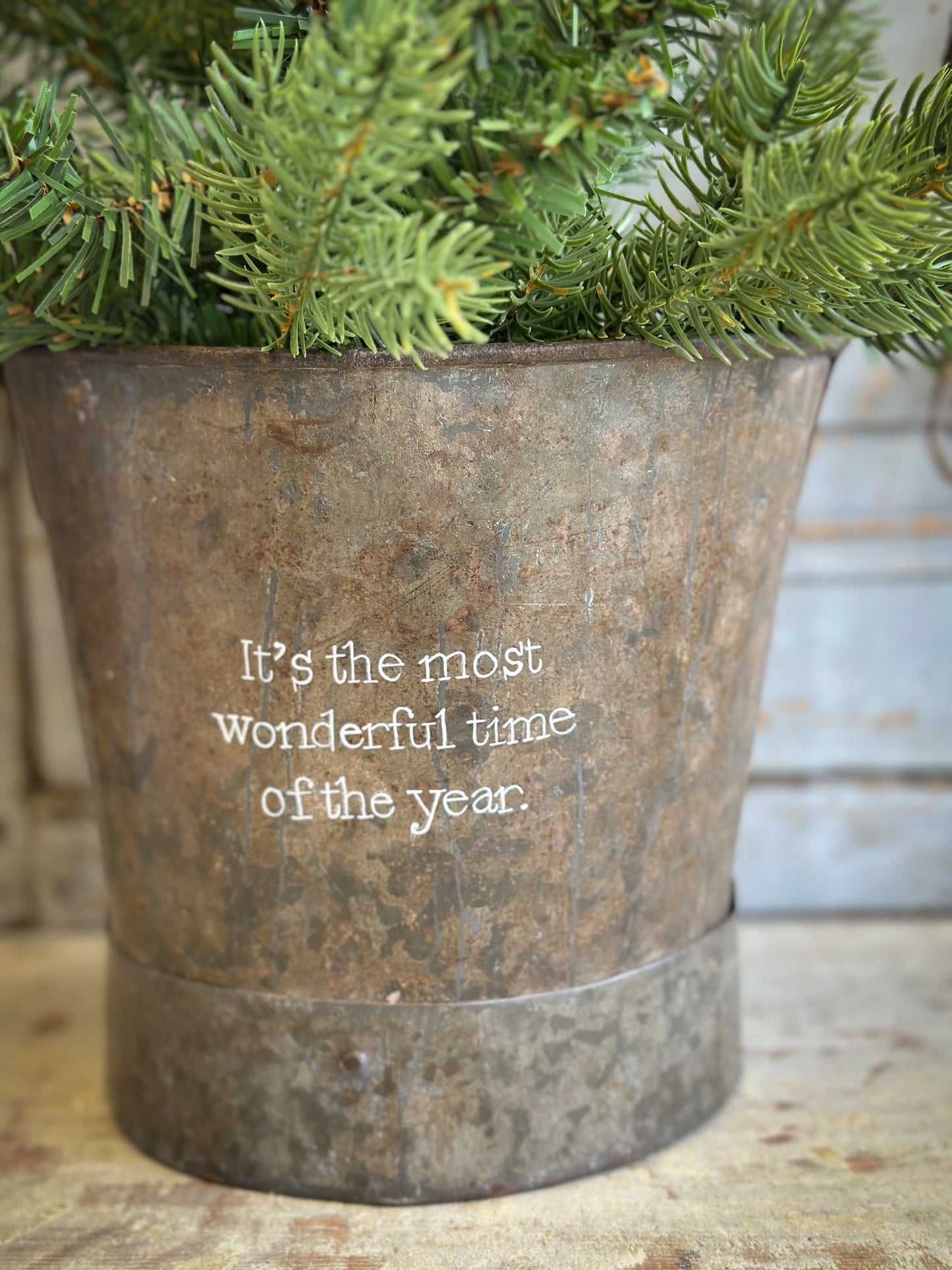 A Recycled Metal Small Christmas Tree Bucket With A Hand Painted Quote
