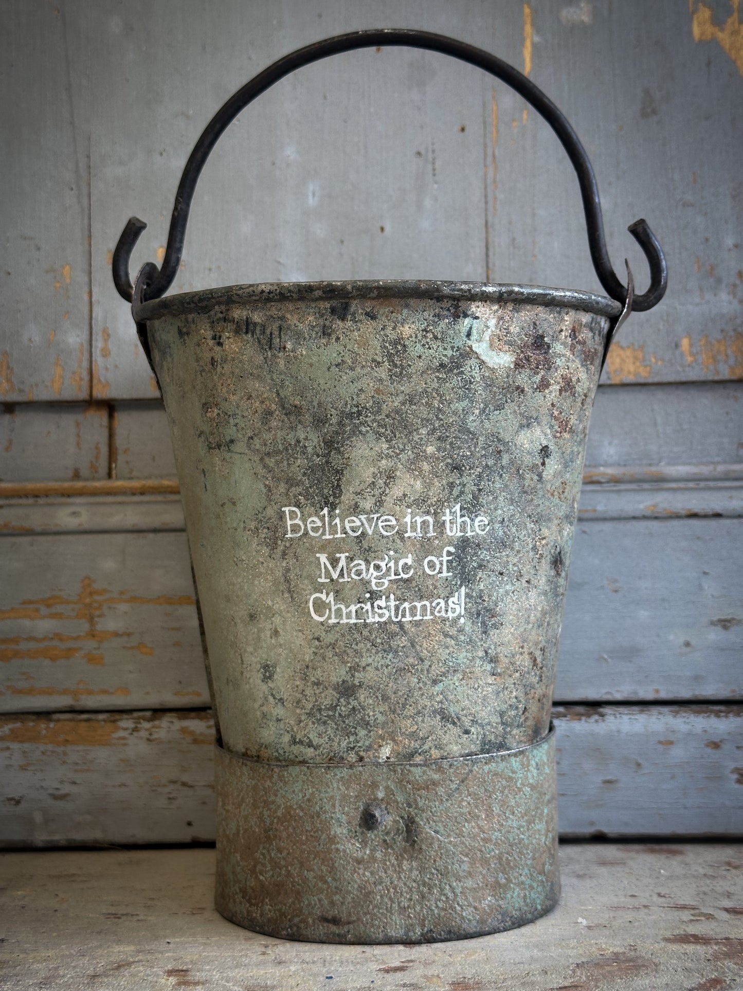 A Recycled Metal Mini Christmas Tree Bucket With A Hand Painted Quote