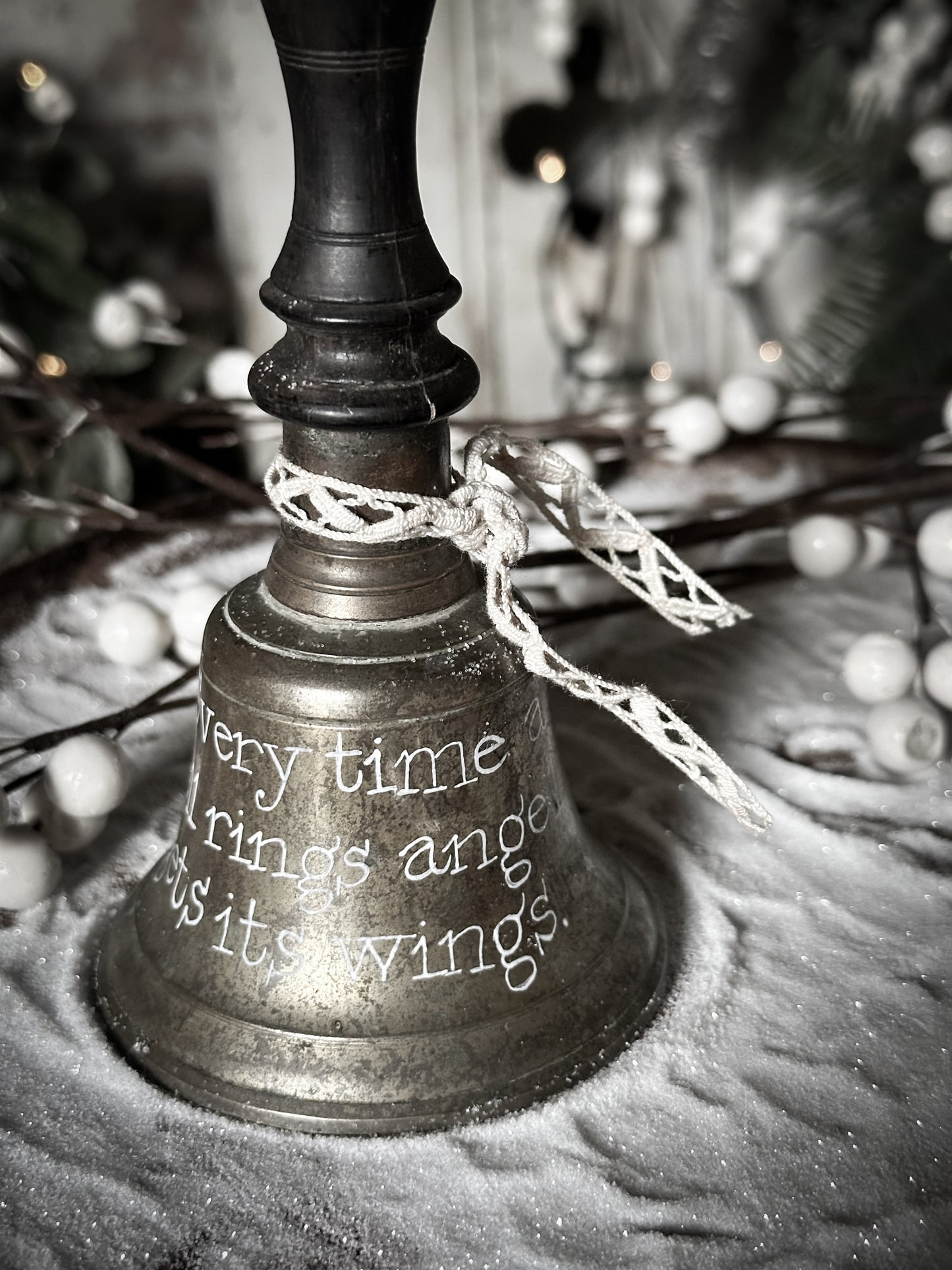 A vintage brass hand held bell with a hand painted quote