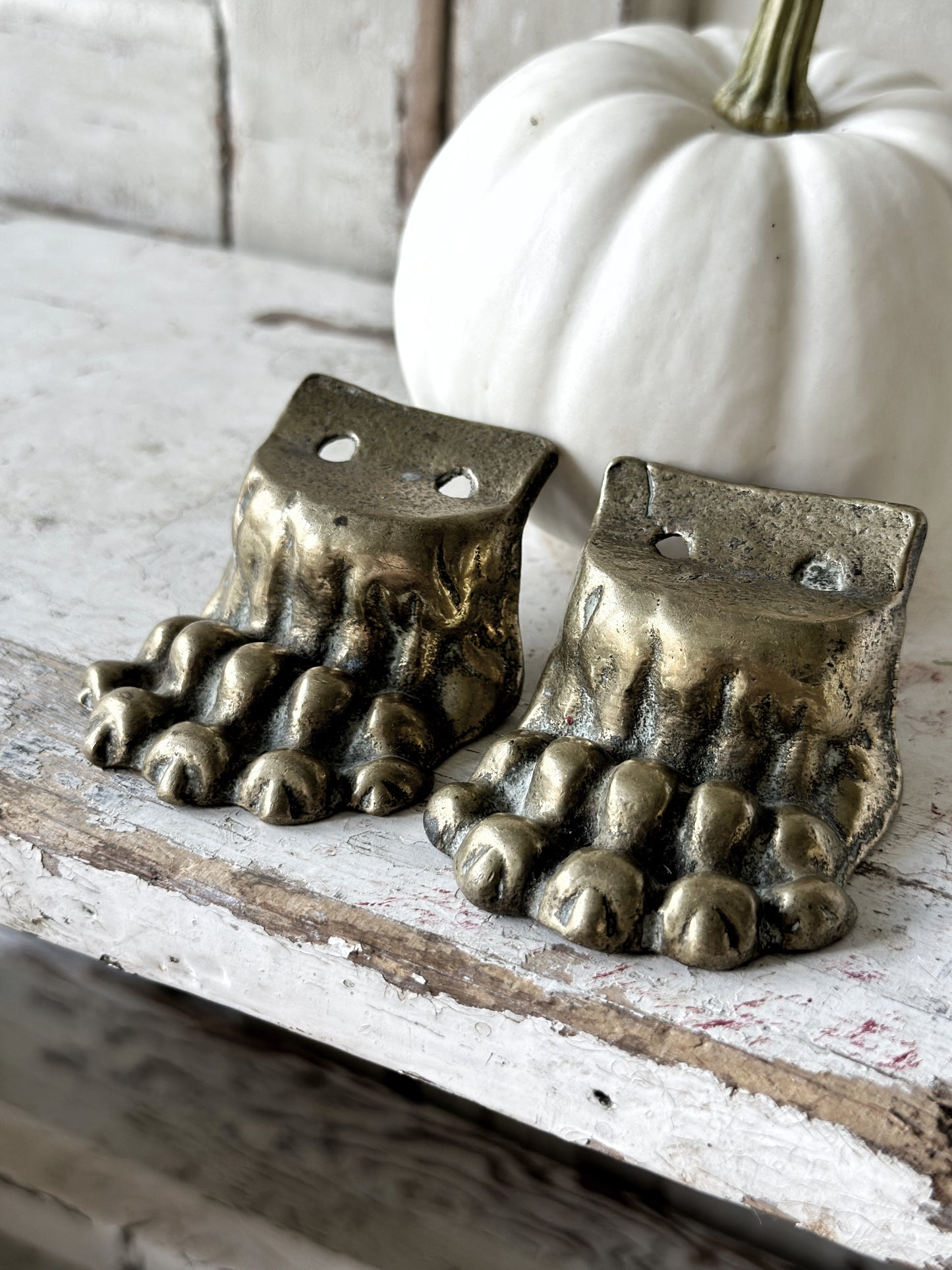 A pair of two antique brass salvaged clawed feet for furniture