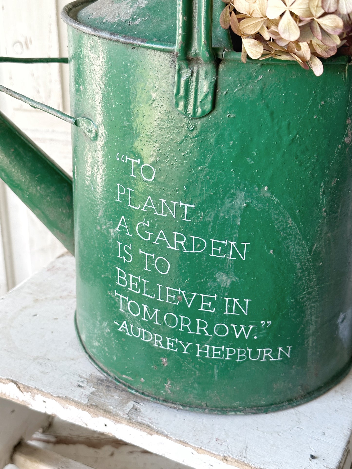 A lovely vintage galvanised watering can painted in a green coloured paint