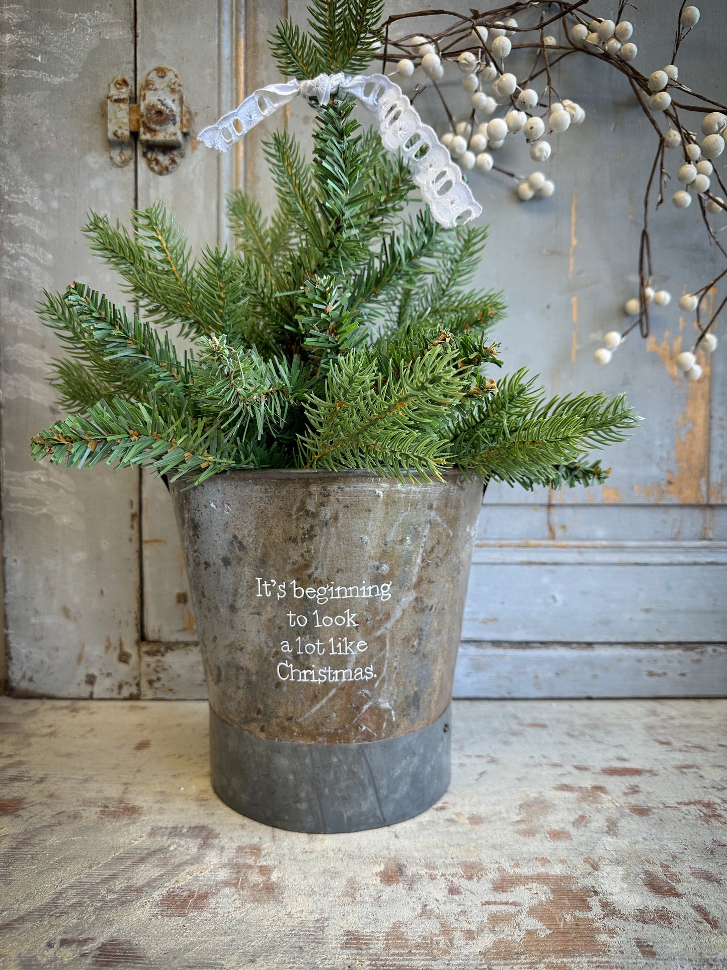 A Recycled Metal Small Christmas Tree Bucket With A Hand Painted Quote