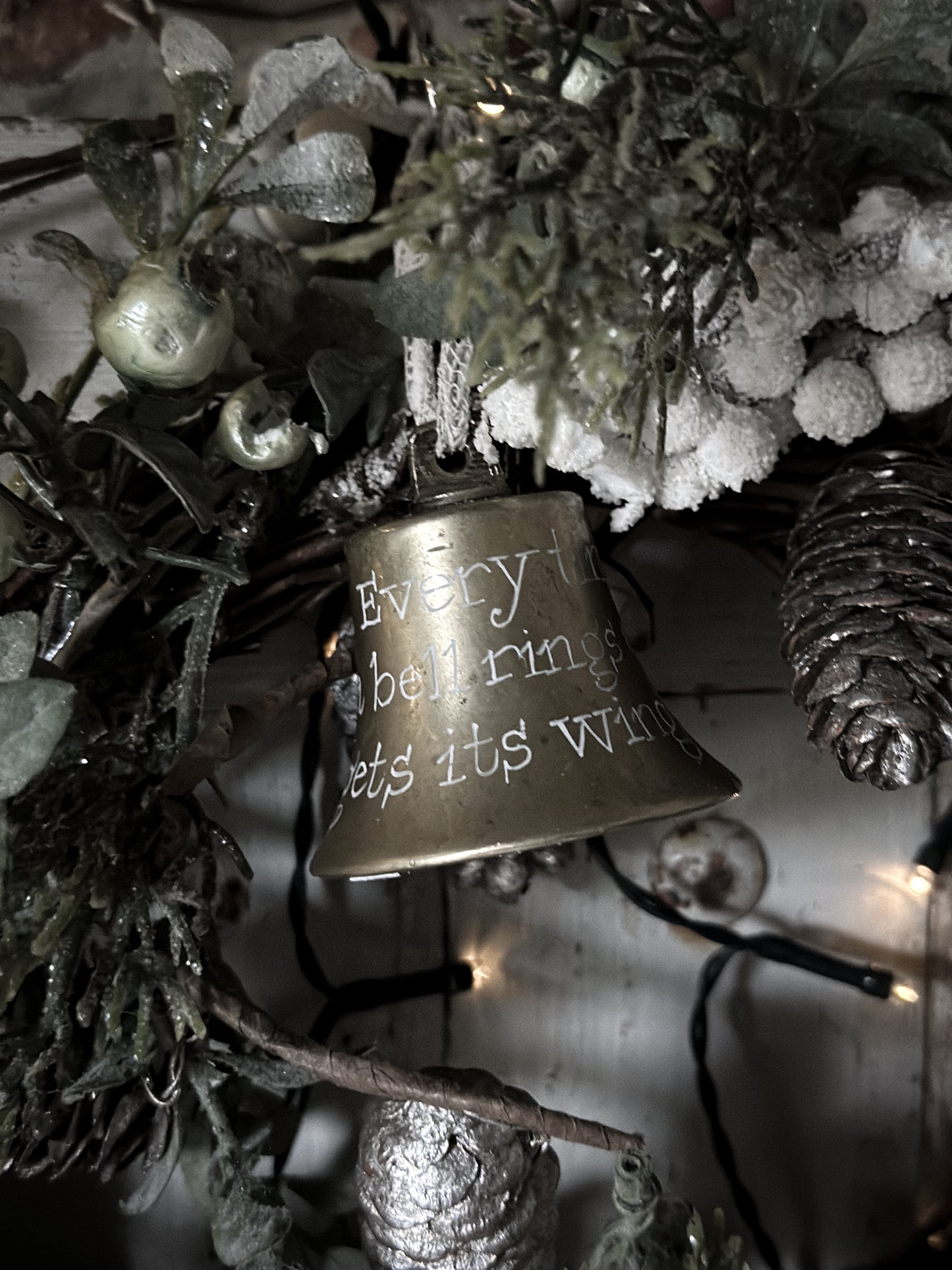 A vintage brass bell with a hand painted quote
