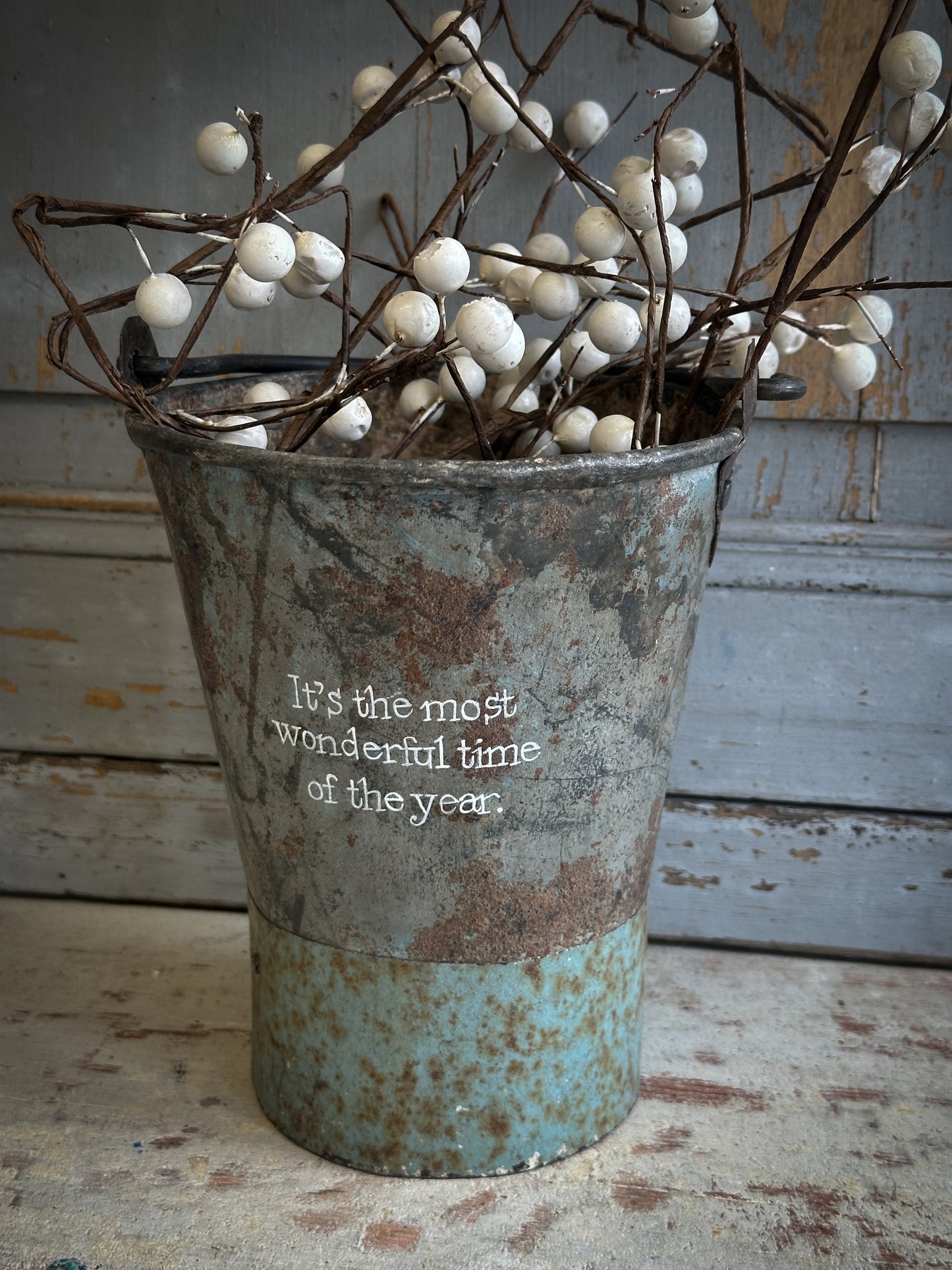 A Recycled Metal Mini Christmas Tree Bucket With A Hand Painted Quote