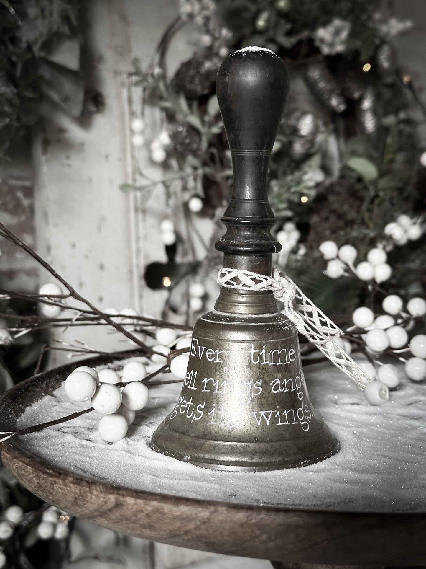 A vintage brass hand held bell with a hand painted quote