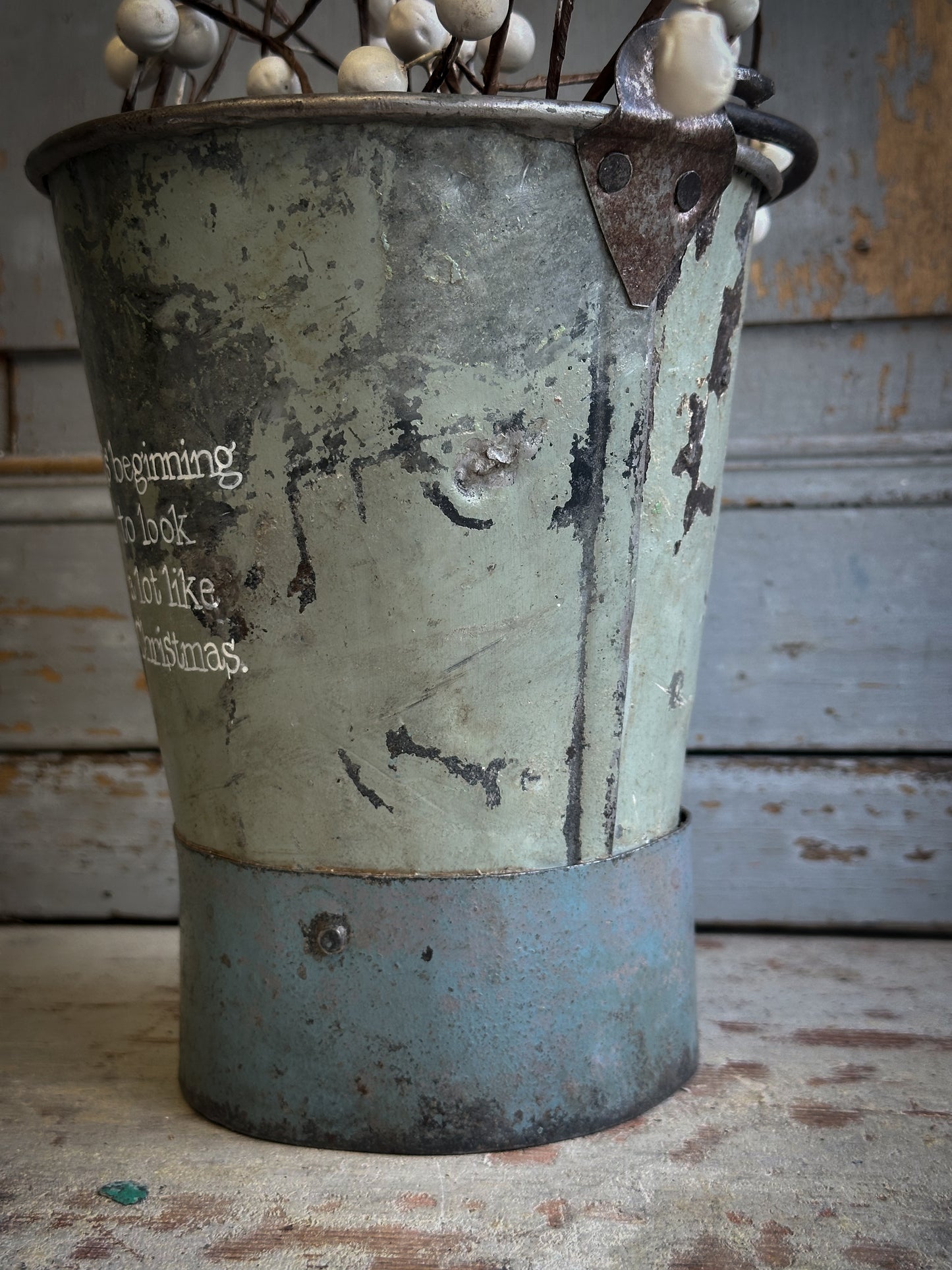 A Recycled Metal Mini Christmas Tree Bucket With A Hand Painted Quote