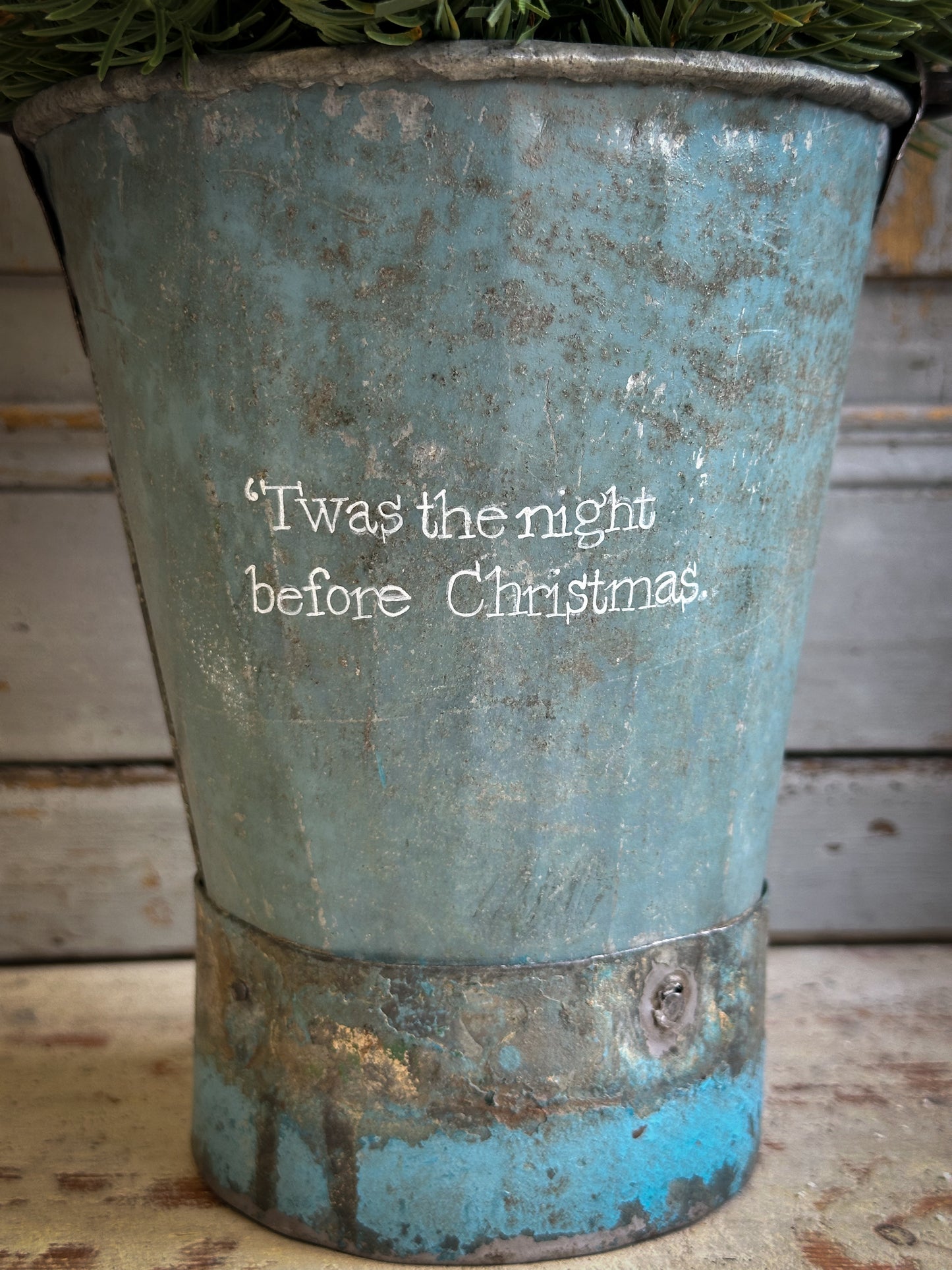 A Recycled Metal Mini Christmas Tree Bucket With A Hand Painted Quote