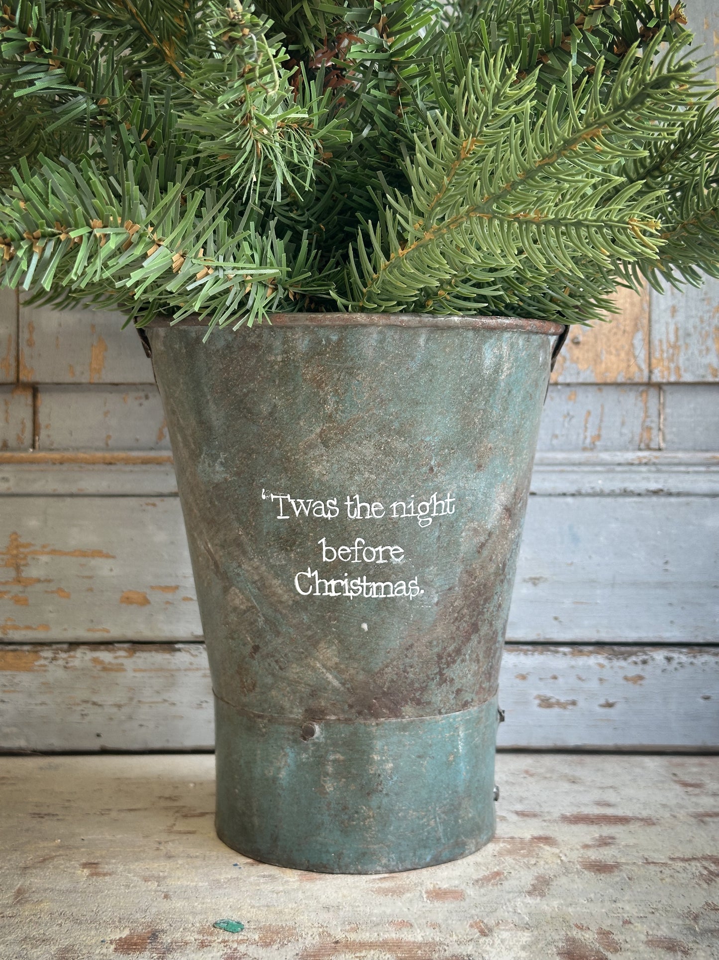 A Recycled Metal Mini Christmas Tree Bucket With A Hand Painted Quote
